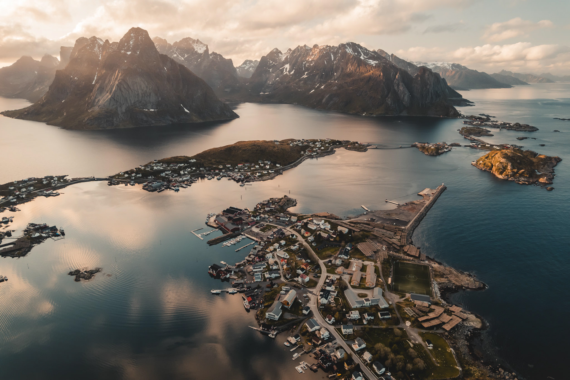 Lofoten Islands Sunset – Stunning aerial panorama of the Lofoten Islands bathed in golden light.