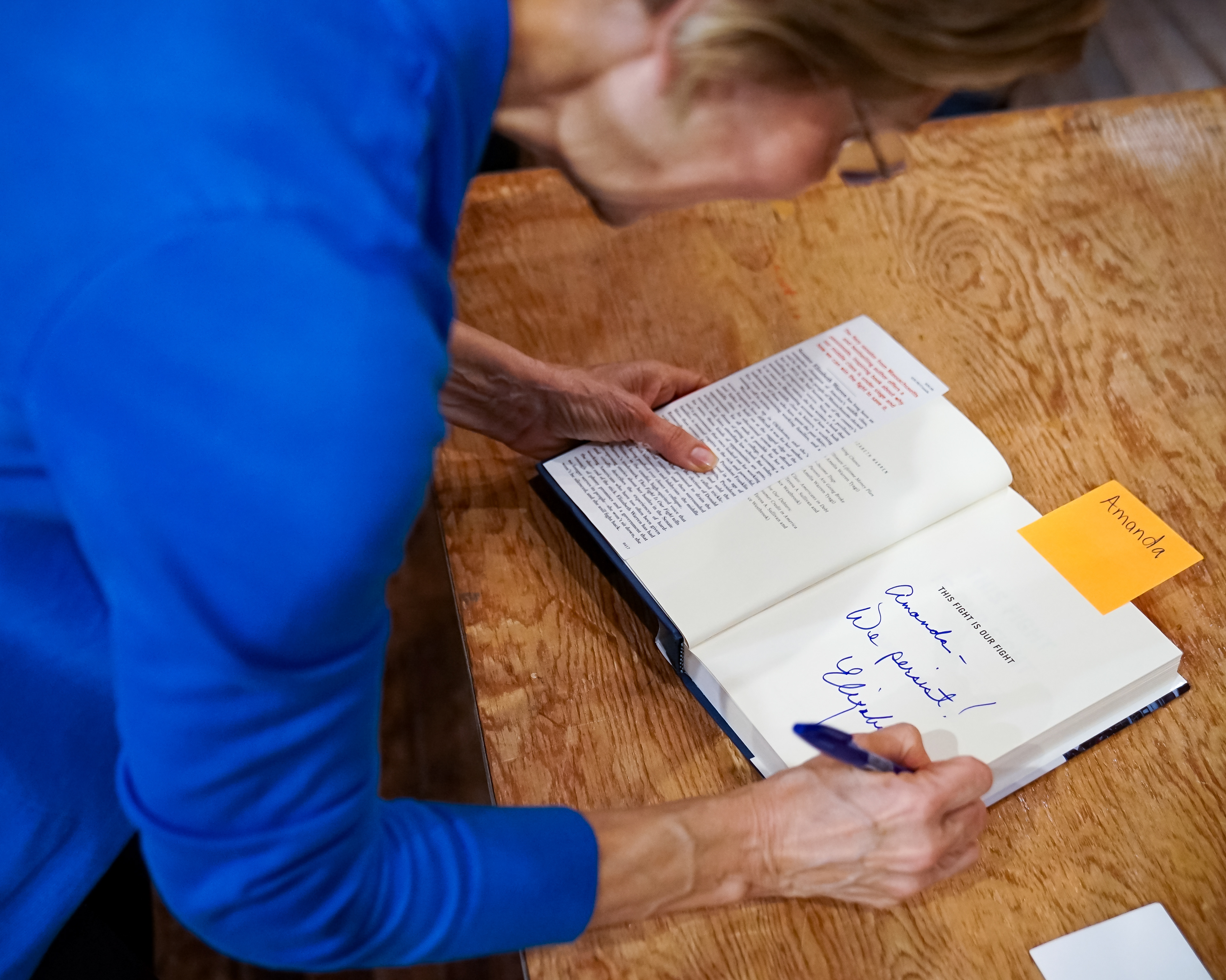 Senator Elizabeth Warren signs her book, This Fight is Our Fight, for a supporter prior to a town hall event on October 21, 2019 at Iowa State University in Ames, Iowa.