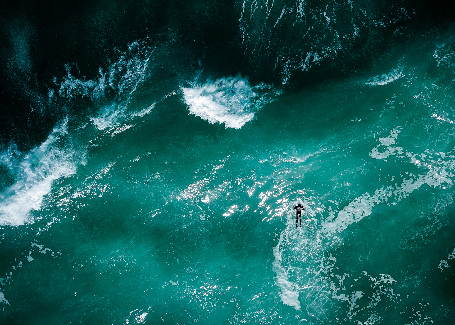 A solo surfer paddles out past the break off the cost of Dunedin on the South Island of New Zealand on April 25, 2018.