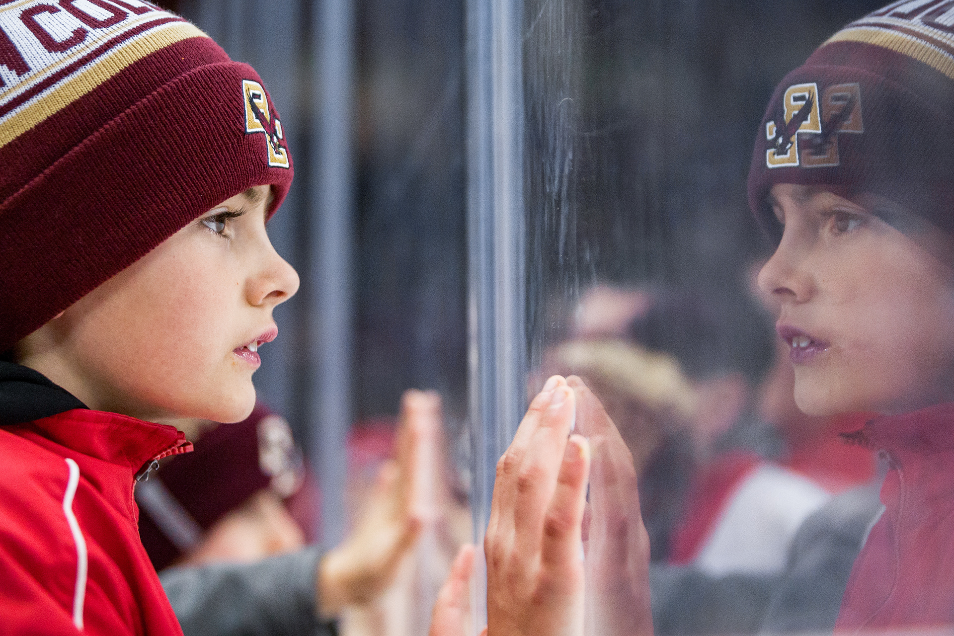A young Boston College Eagles fan looks on through the boards during a game between the Eagles and the Northeastern University Huskies on December 9, 2017 at Conte Forum in Boston, Massachusetts. The Huskies defeated the Eagles 5-2.