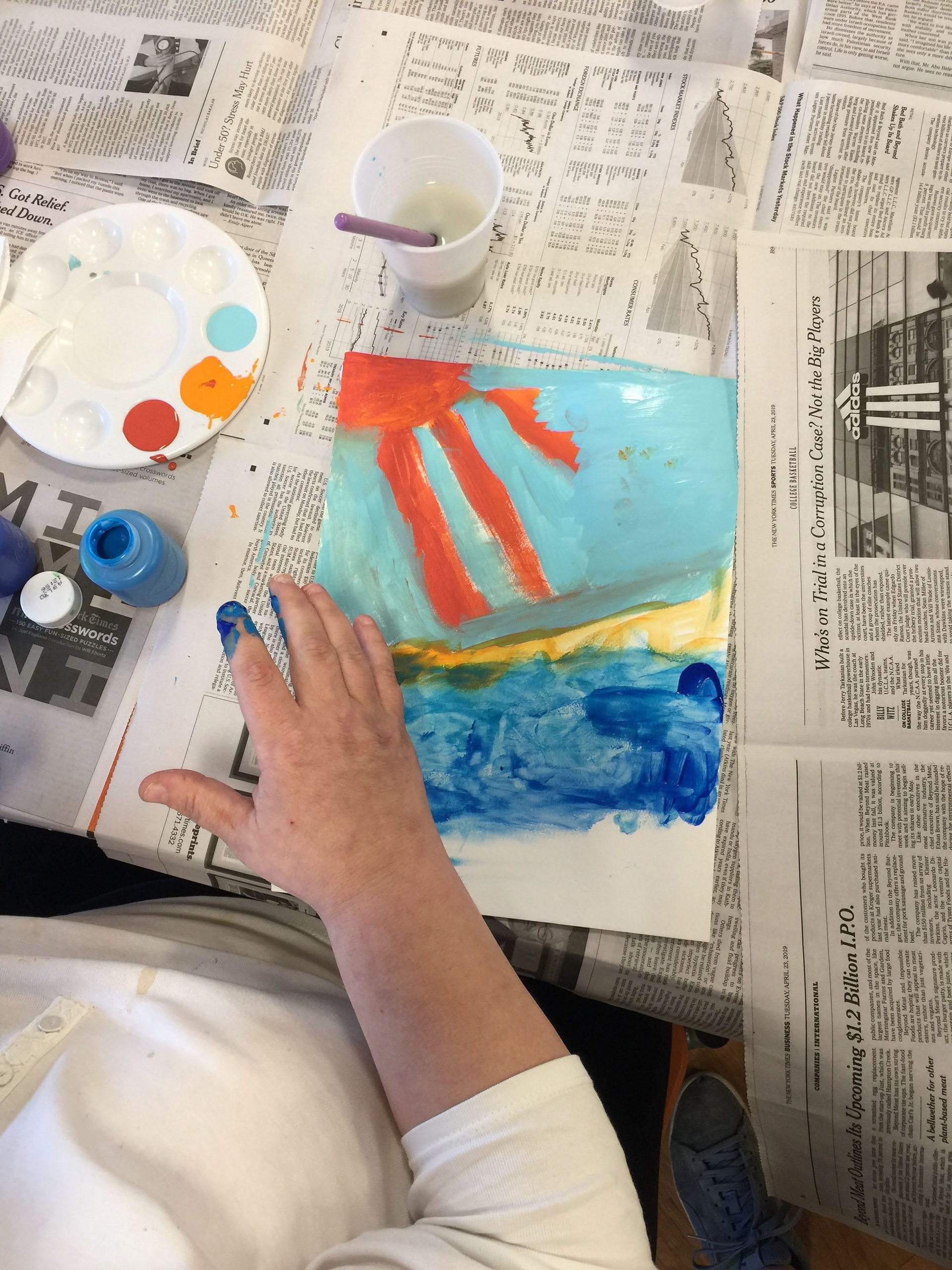A resident creates a colorful finger painting of a beach.