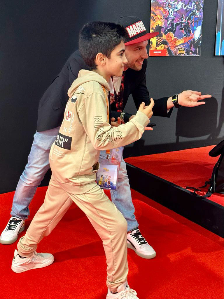 Roberto stops to pose for a pic with a young comic book fan.