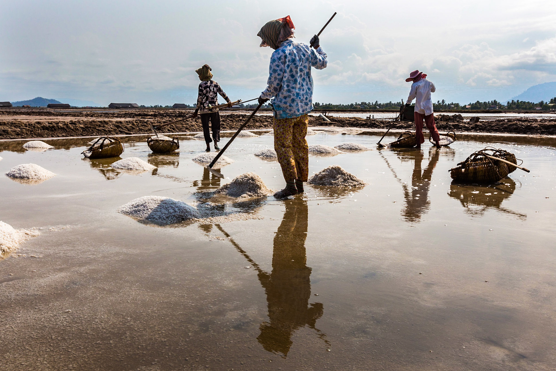 A salt farm where the local women are harvesting the salt that has formed from the evaporating sea water