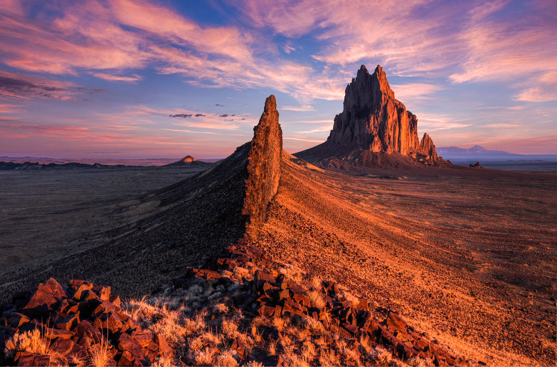 The stunning Shiprock seemingly exploding out the flat ground that surrounds it with the wall walling of the east and west of the dry desert plains