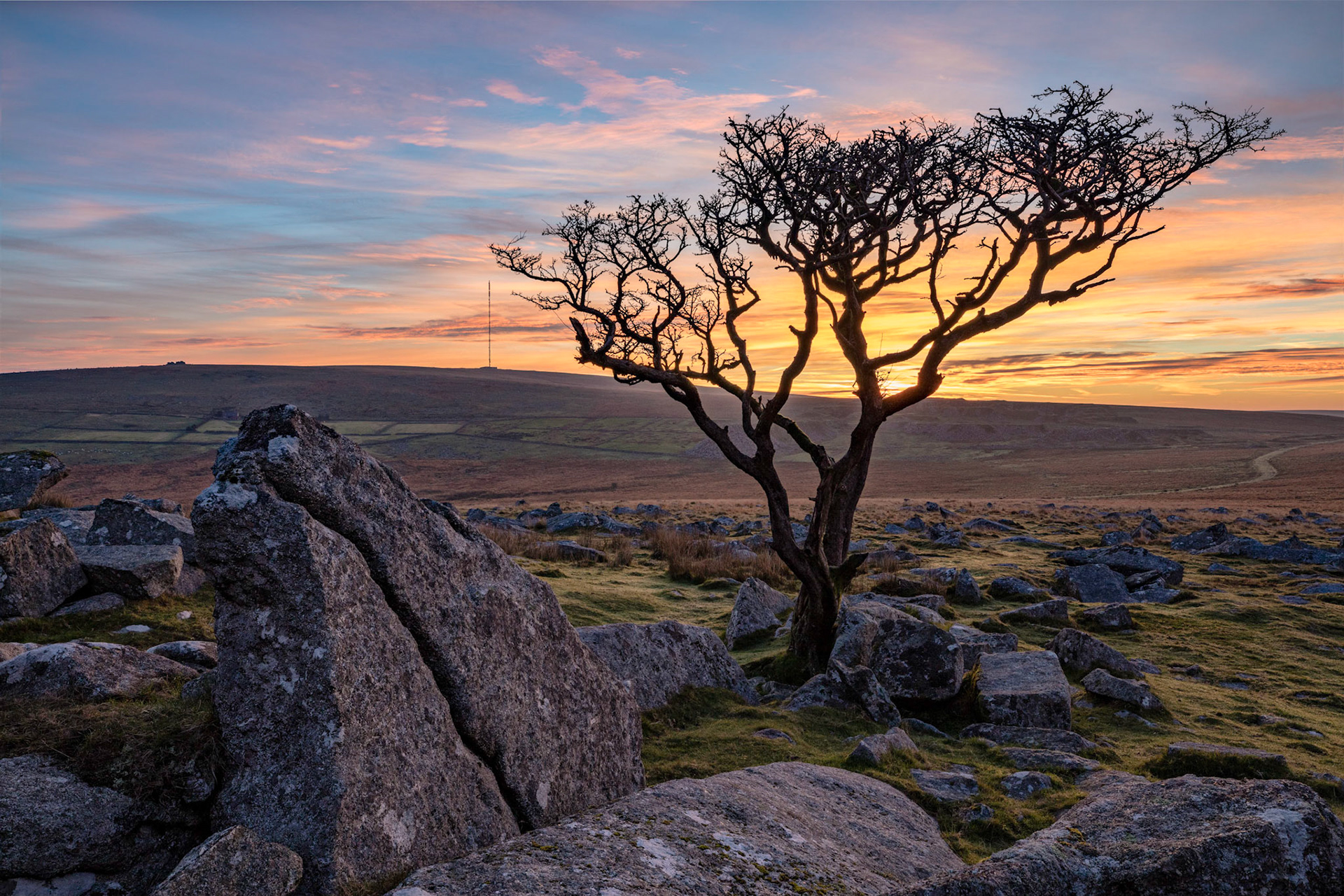The morning sun illuminating the clouds over Kings Tor in Dartmoor National Park looking towards Princetown