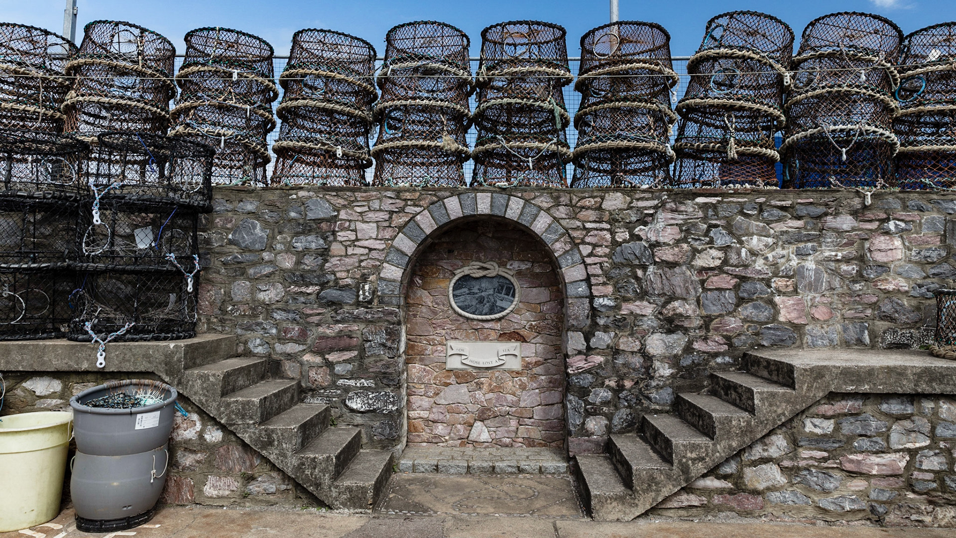 Stacked crab pots on the harbor wall in Brixham