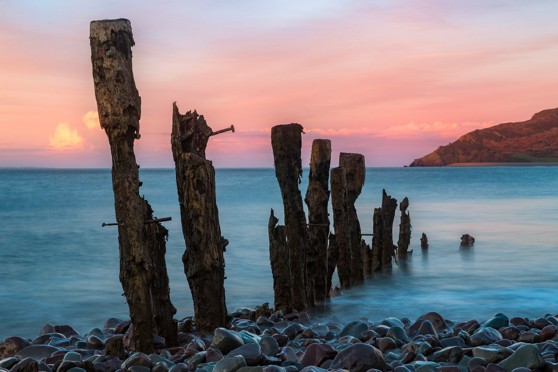 What is left of a wooden groynes worn by the sea an other elements on the northern coast of Somerset near Porlock Wear, UK