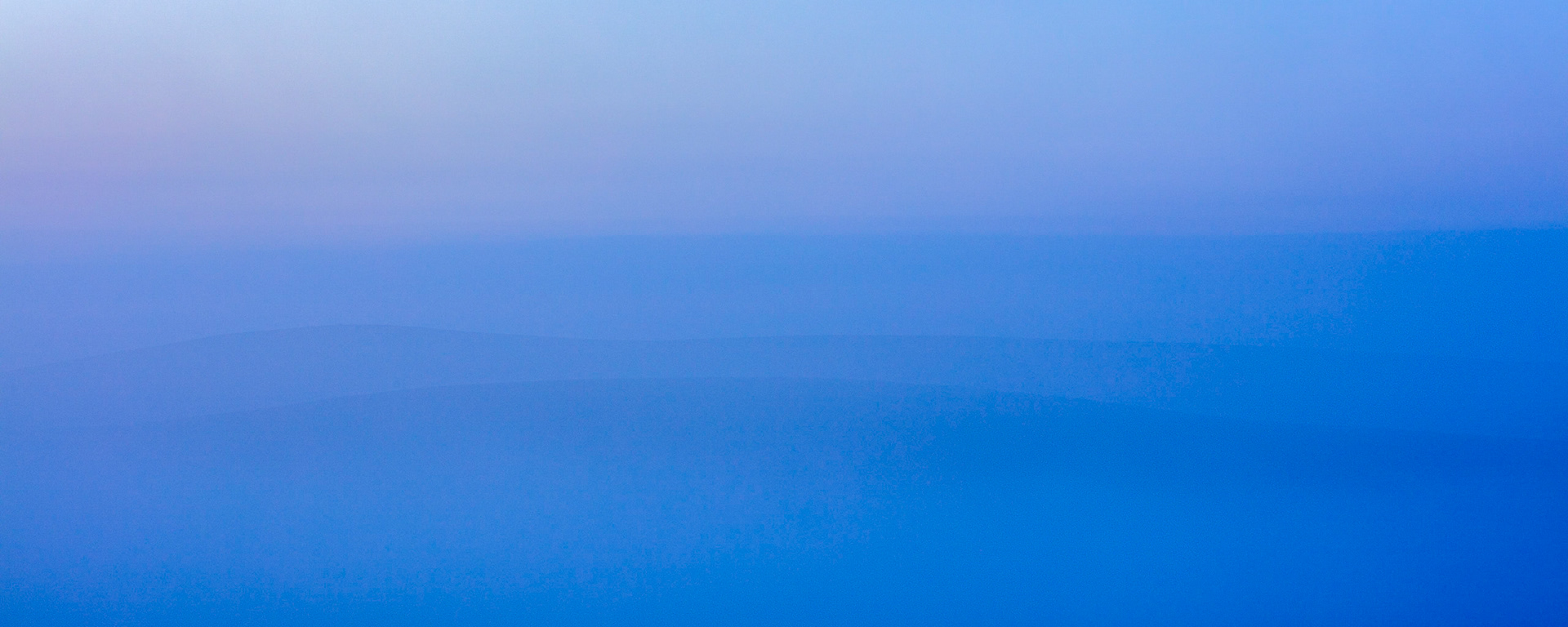 The moorland hills of Dartmoor National Park just peering through the morning mist.