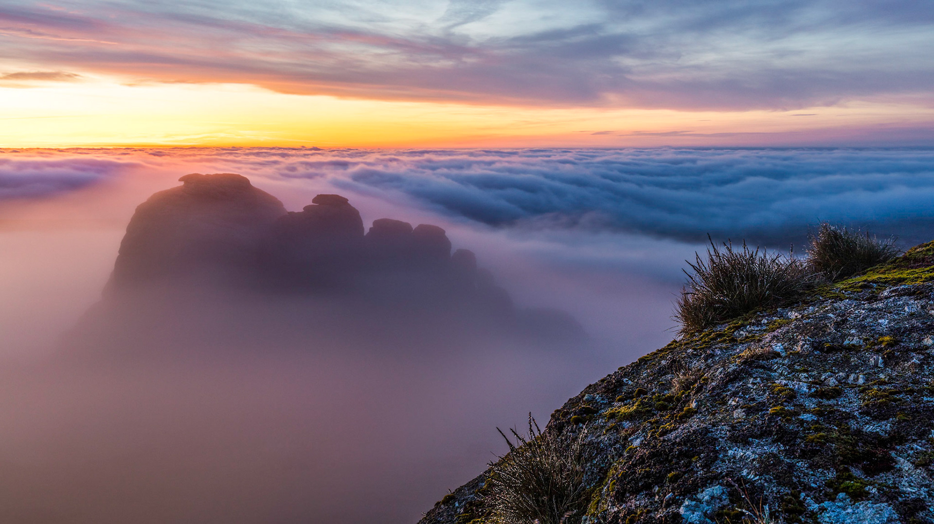 Haytor rocks emerging from the low lying clouds just before sunrise in Dartmoor National Park, Devon, England.