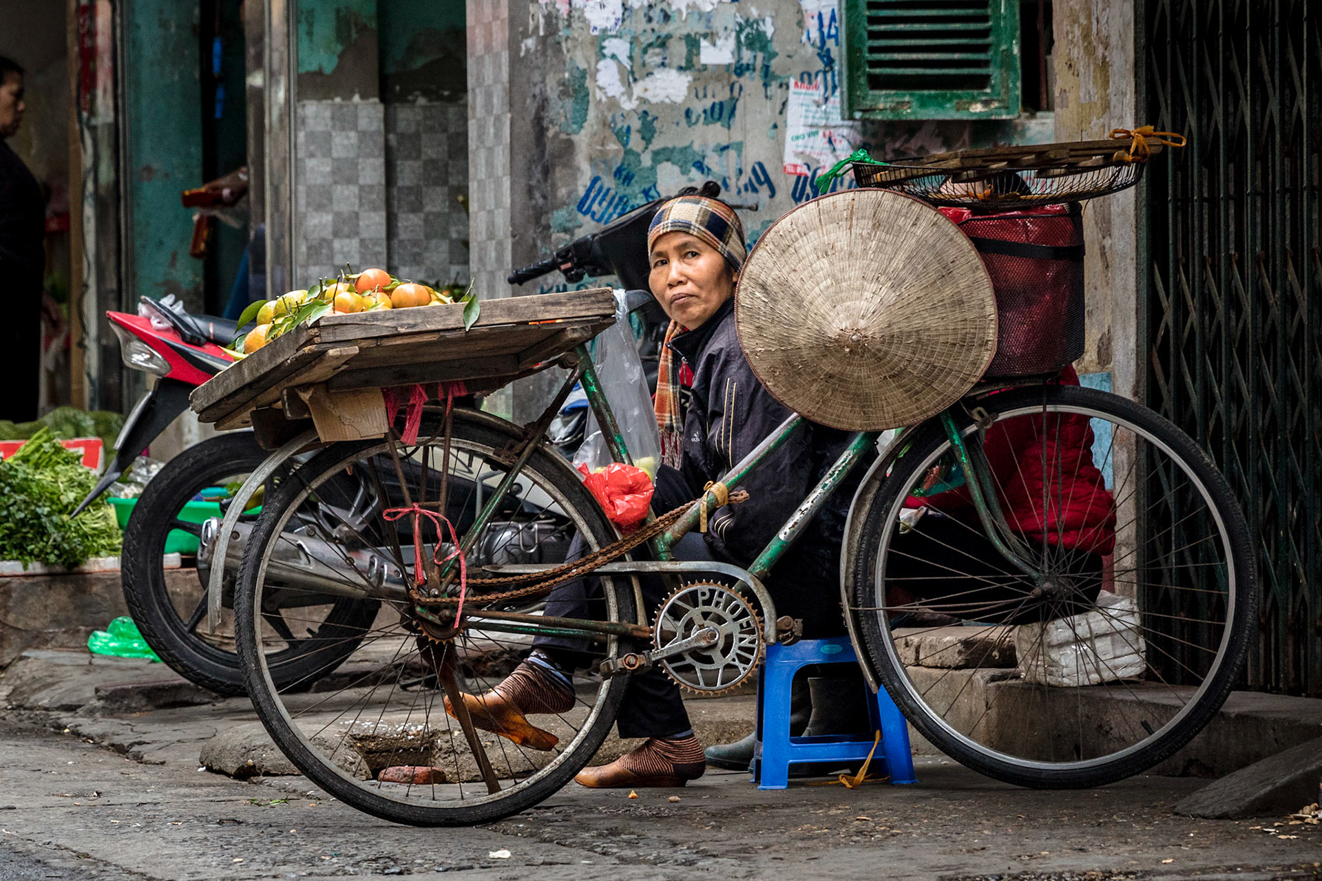 A woman selling vegetables on the back of her bike on one of the narrow roads in Hanoi.
