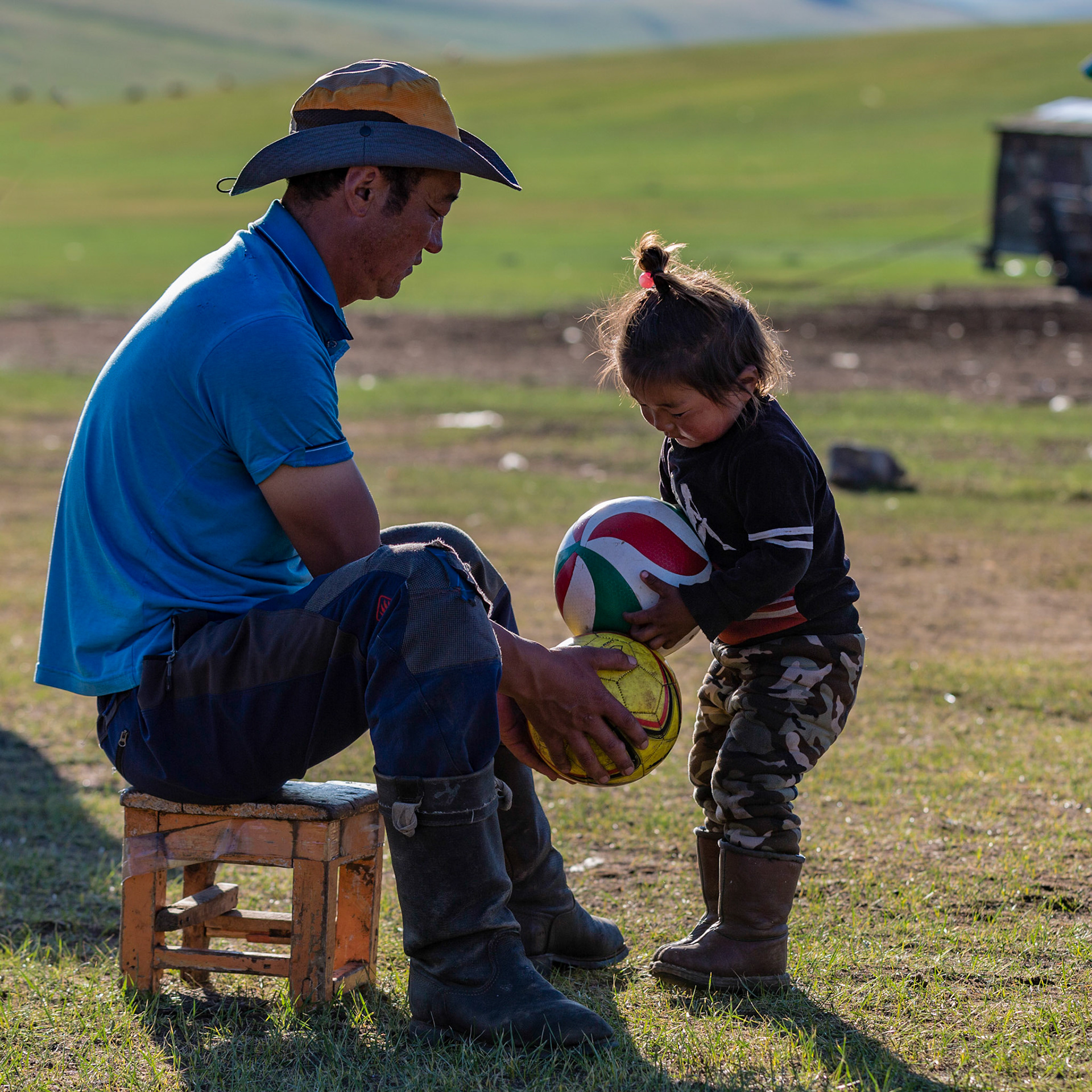Father and daughter playing with a couple of balls.