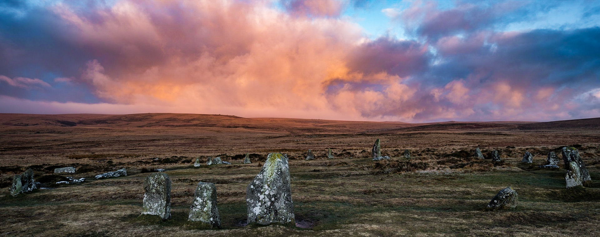 Scorhill stone circle at sunrise with the clouds brilliantly reflecting the early morning sun. Scorhill stone circle is located in Dartmoor national park near Frenchbeer, a settlement in Devon, England.