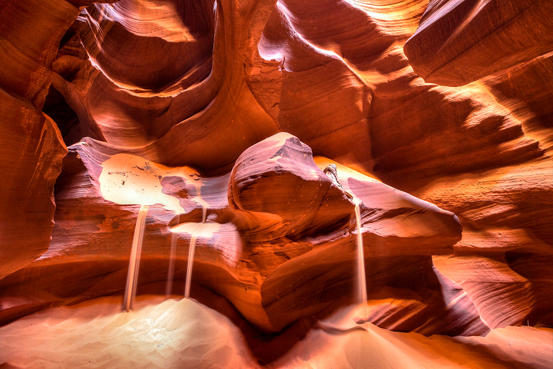 Sand falls in Antelope canyon. The way these sand falls is accomplished in a manual process of scooping sand on the rocks but simulates what it could look like after a mass amount of sand had blown through the canyon