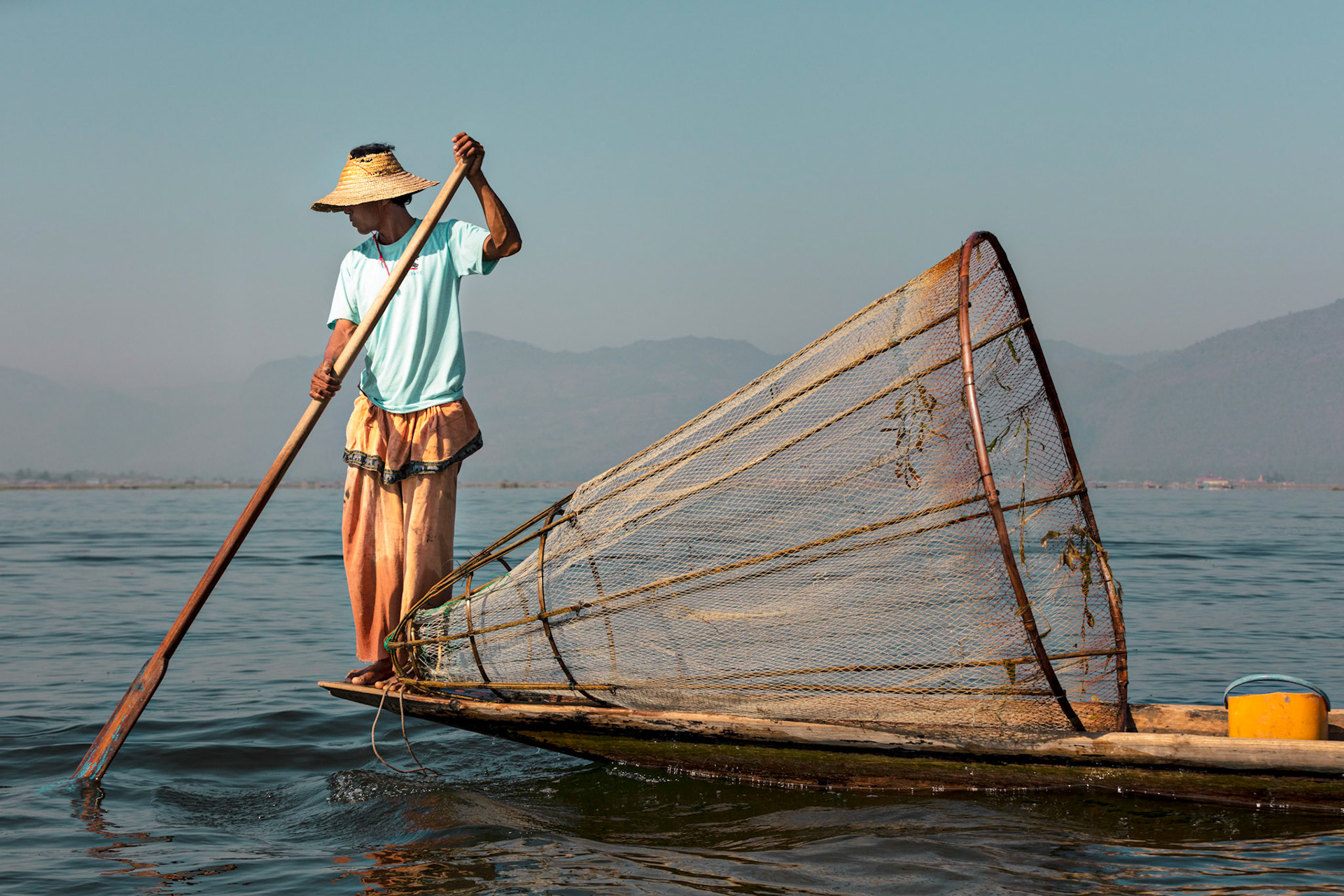 Burmese local fisherman looking for a good place to drop his net to catch some fish on Inle Lake, Myanmar.