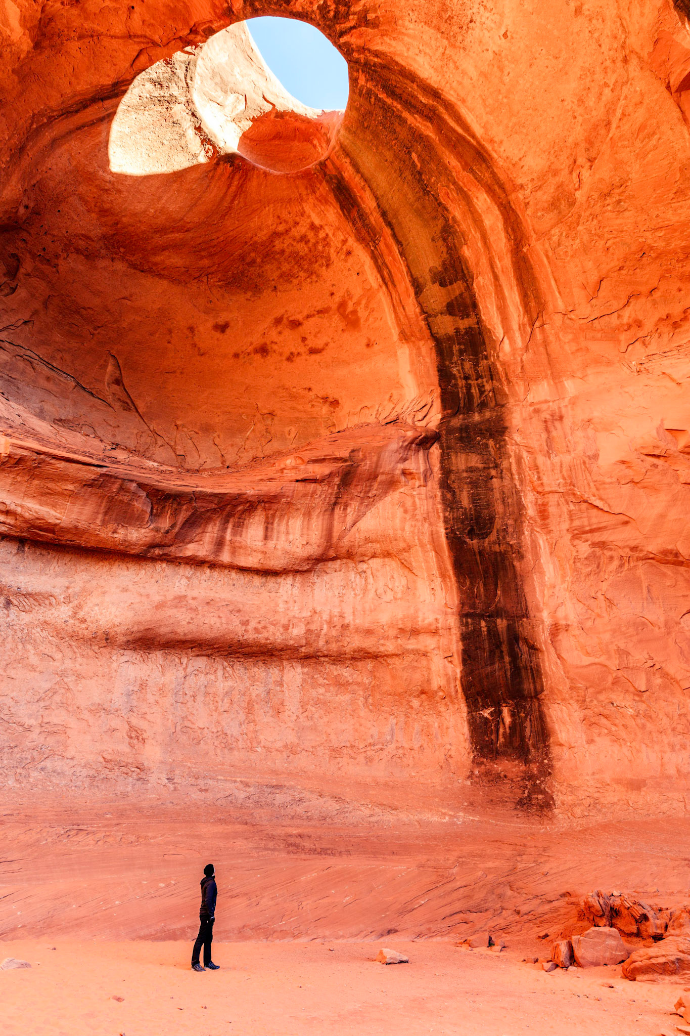 Self portrait looking through Big Hogan arch at the top of a natural amphitheatre in Monument Valley Navajo Tribal Park, Arizona, USA.