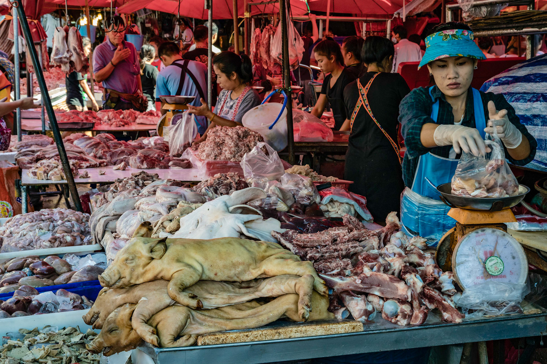 Woman weighing some meat to sell at a local market