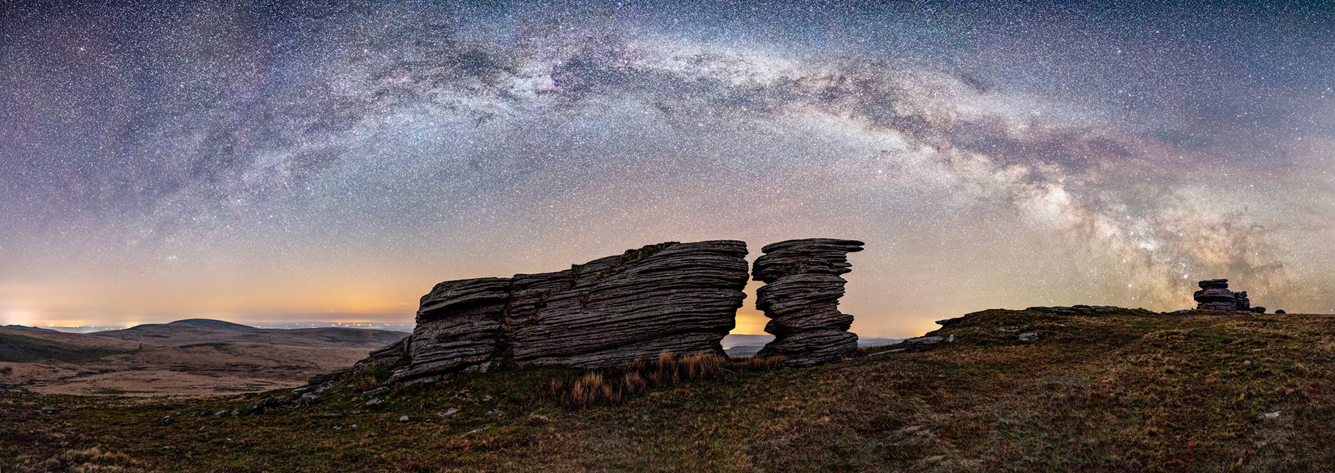 The Milky Way galaxy stretching across the night sky over Watern tor in Dartmoor National Park.