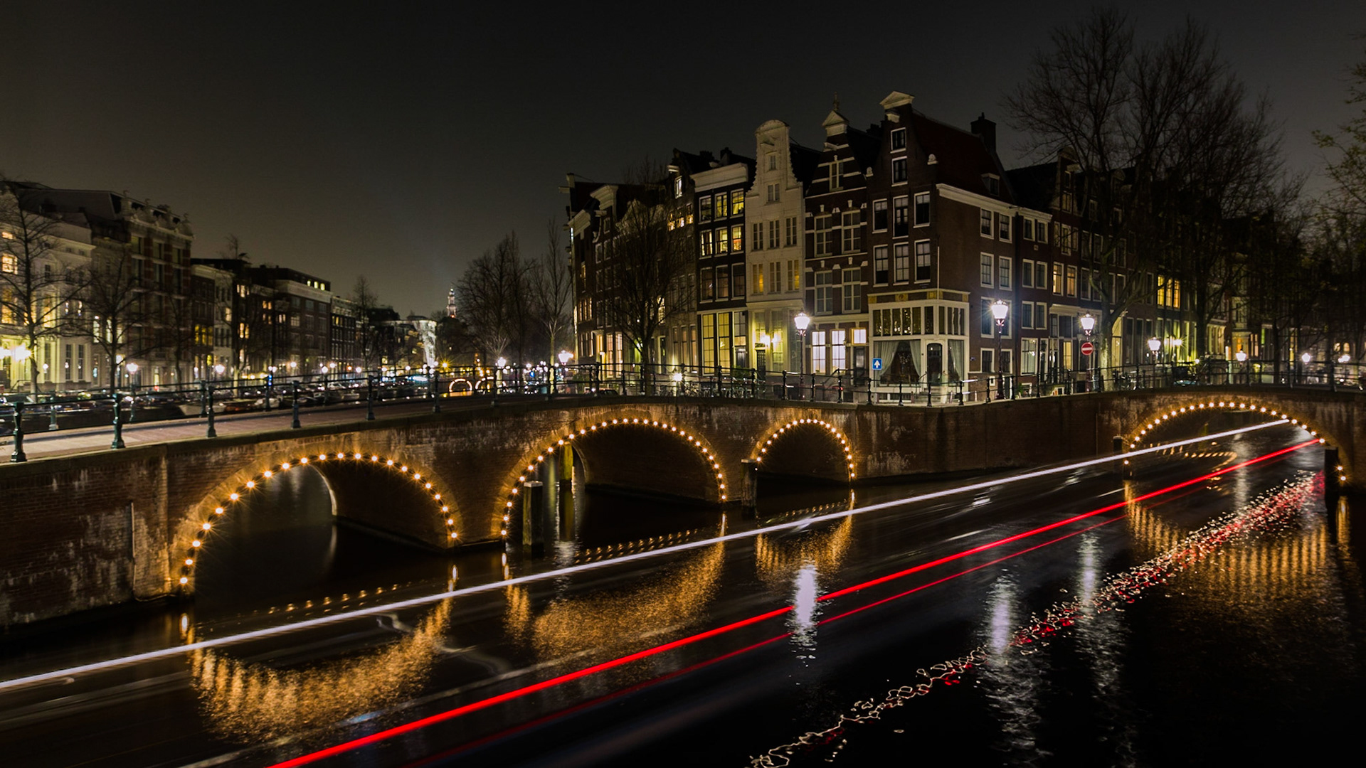 On the corner of Keizersgracht and Leidsegracht in Amsterdam with a long exposure stretching out the tour boat lights