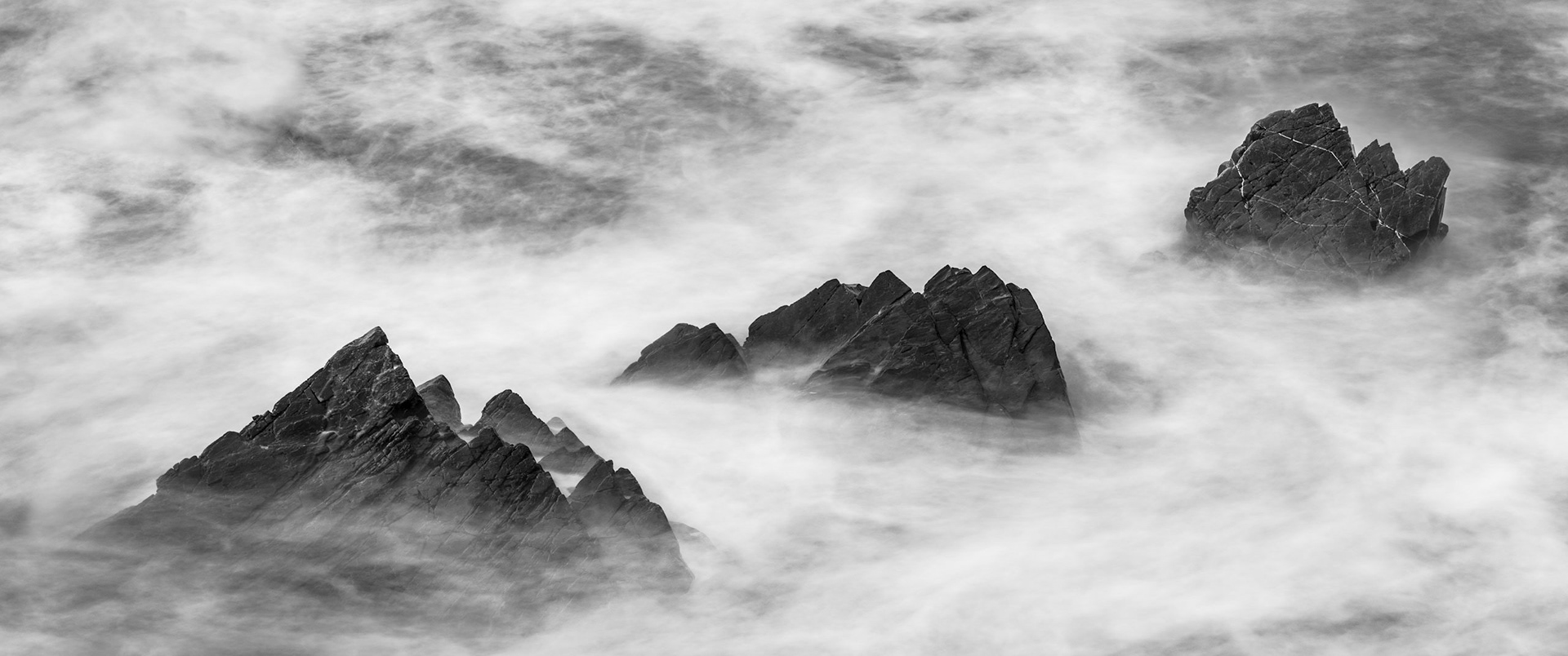 Three rocks partially exposed due to the incoming tide at Hartland Quay in North Devon.