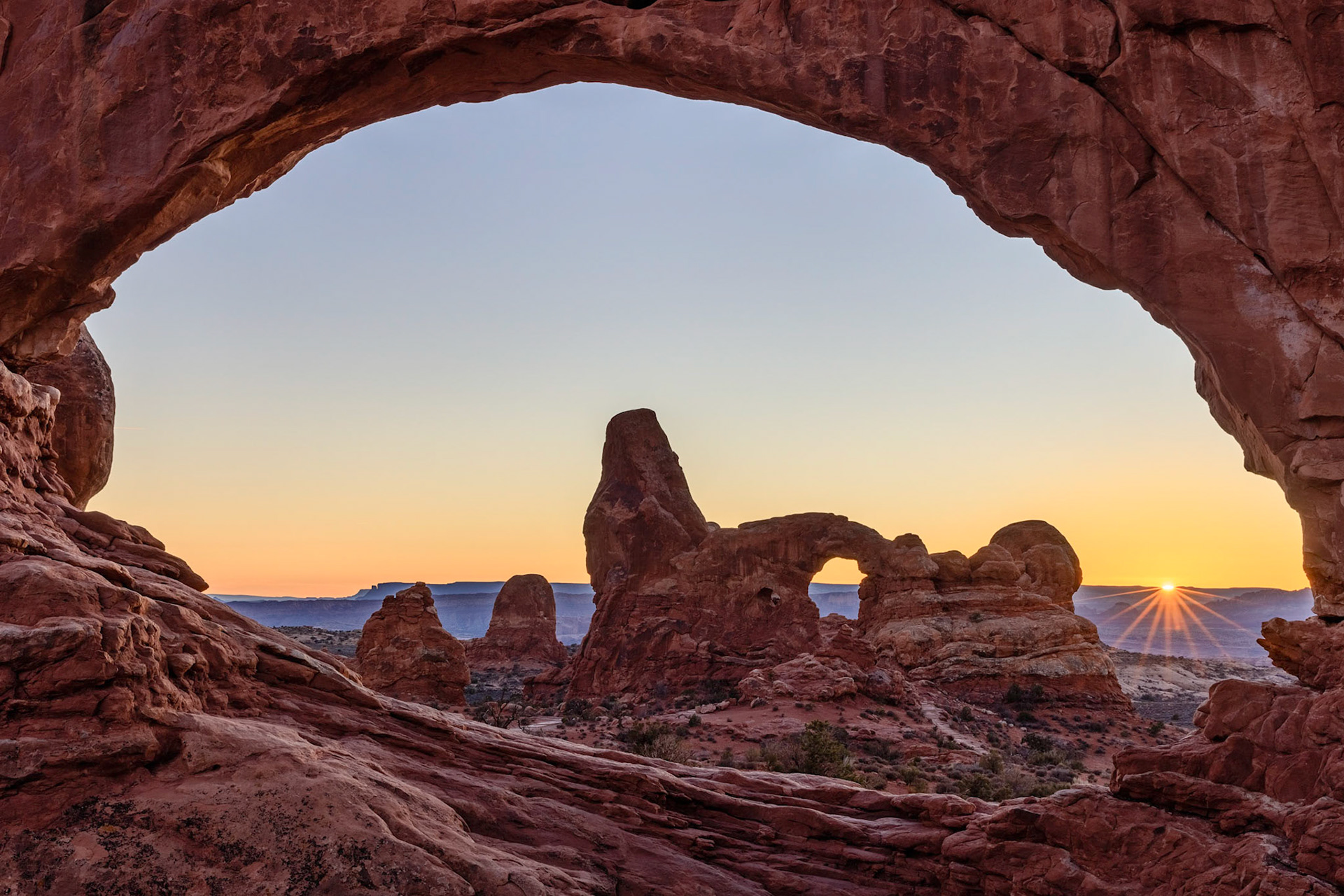 Looking through the North Window Arch towards Turret Arch during a winter sunset in the windows section of Arches National Park, Utah, USA.