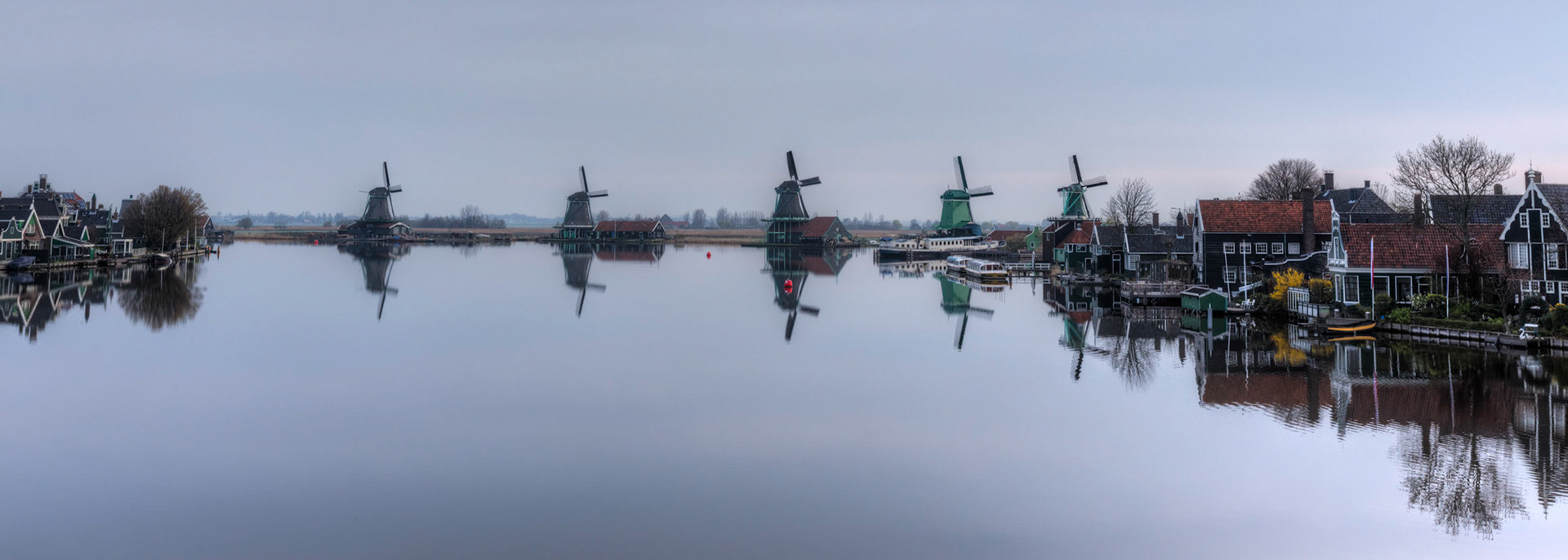 The windmills in Zaanse Schans, north of Amsterdam, on a calm cloudy morning.