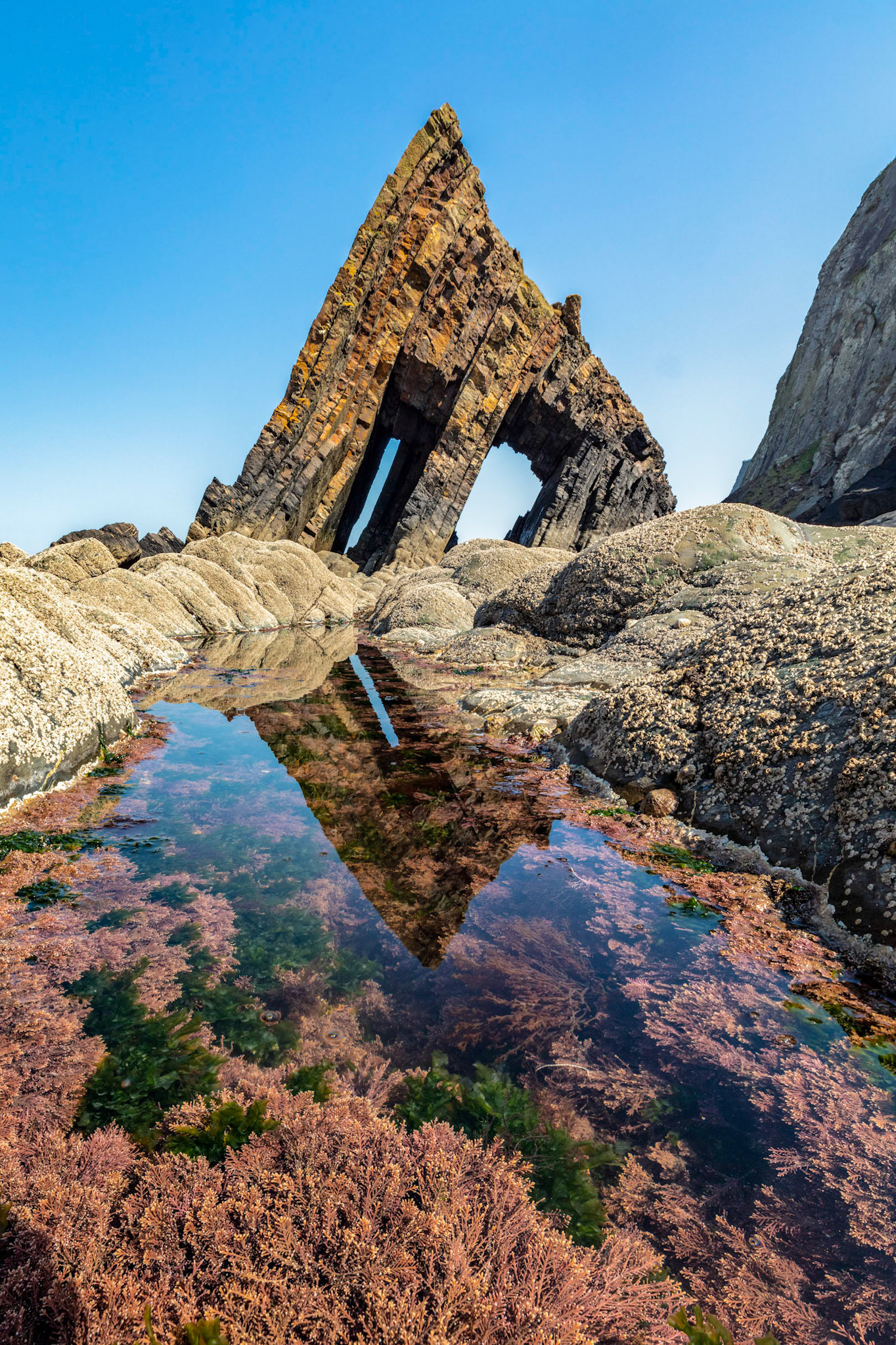 Blackchurch Arch reflecting in a tidal pool in North Devon on Mouth Mill Beach