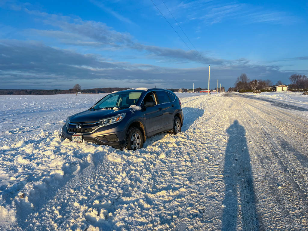 winter photo of a vehicle stuck in a snowbank