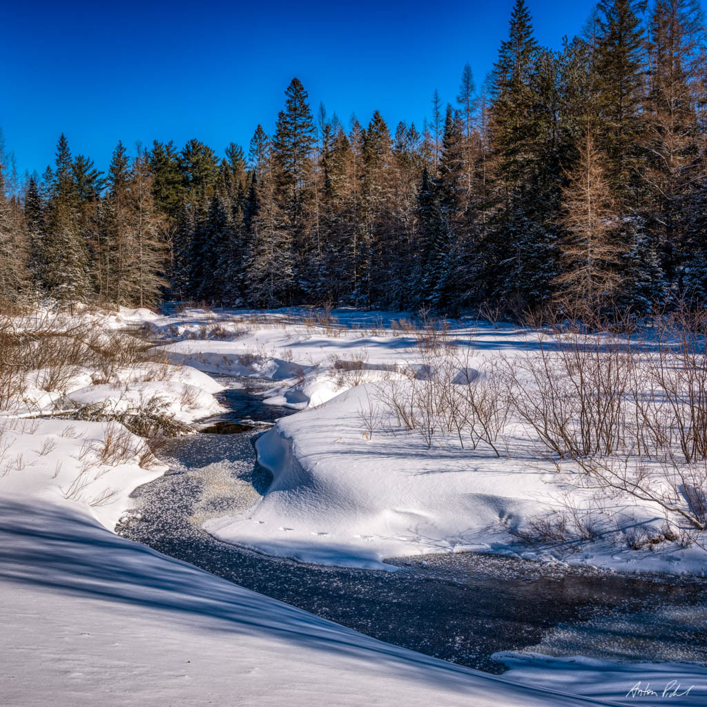 daytime photo of a frozen stream and snow