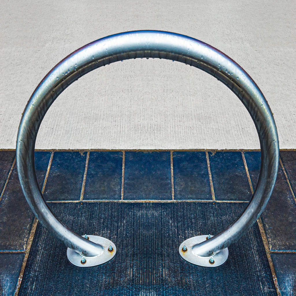 a photo of a sidewalk circular bicycle stand