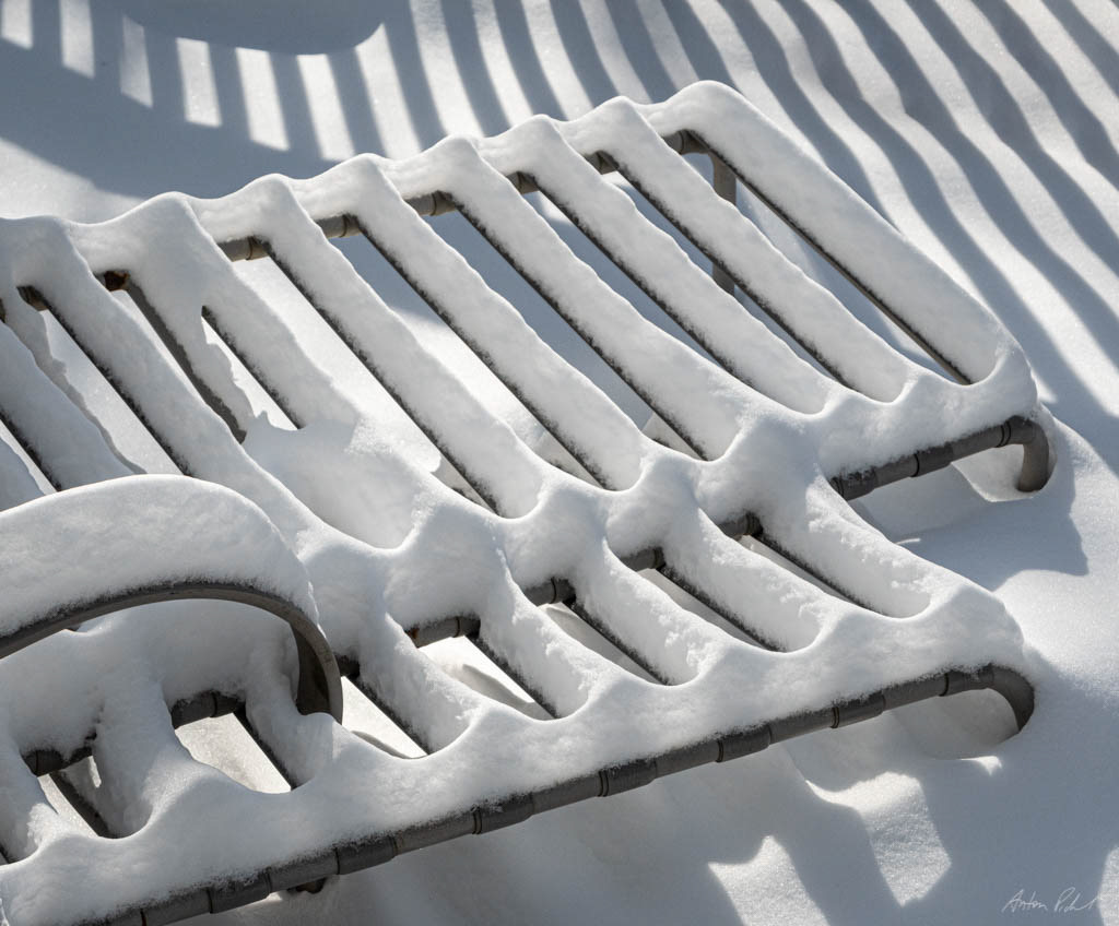 photo of deck chairs covered in snow