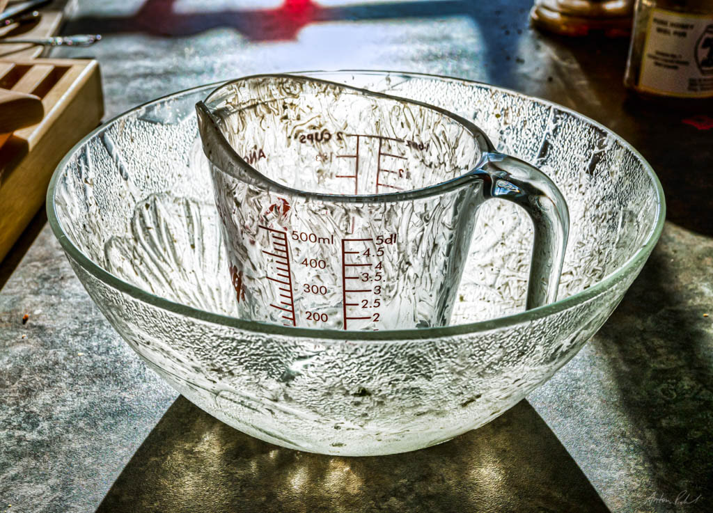 photo of glass bowl and measuring cup that are backlit by the sun