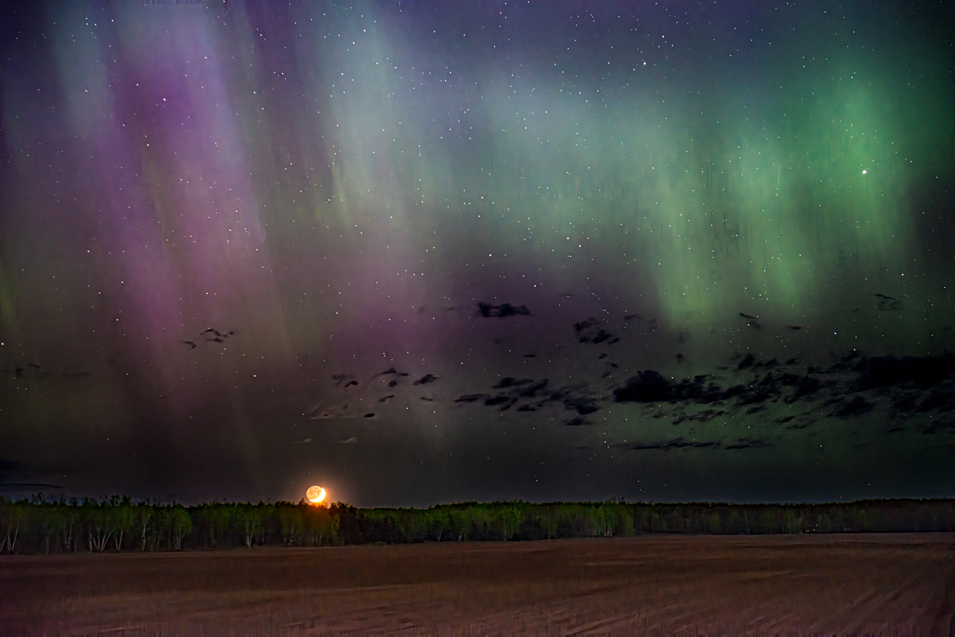 wide angle image of aurora with setting moon