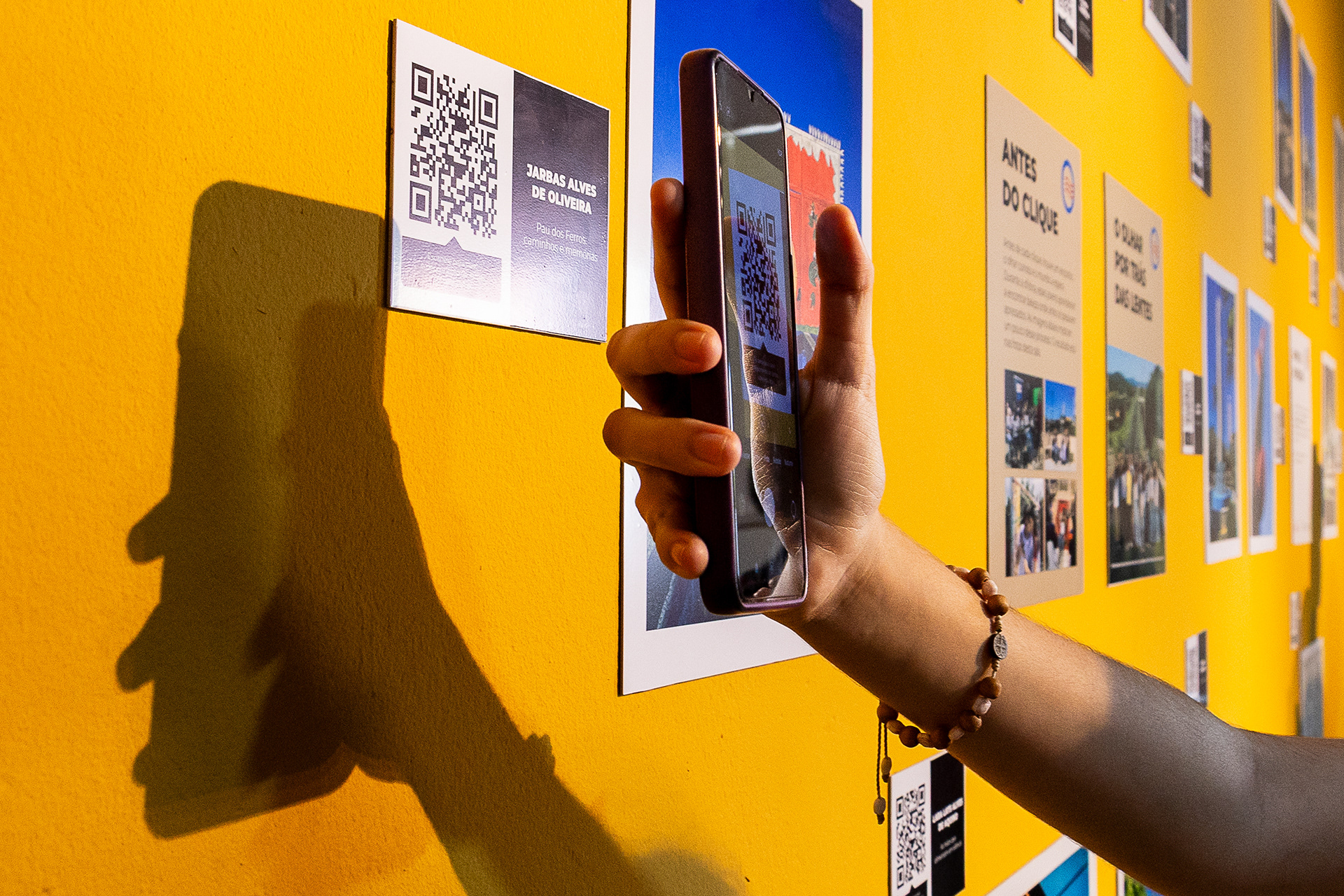 Visitante escaneia QR code na exposição