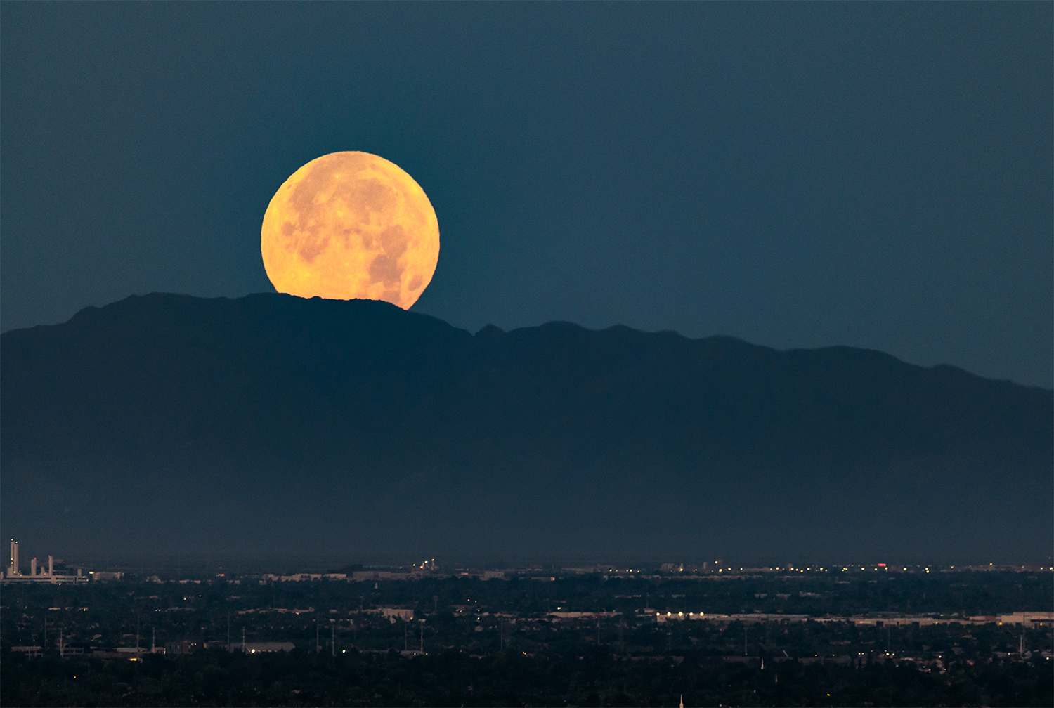 Strawberry Supermoon setting behind the Mountains
