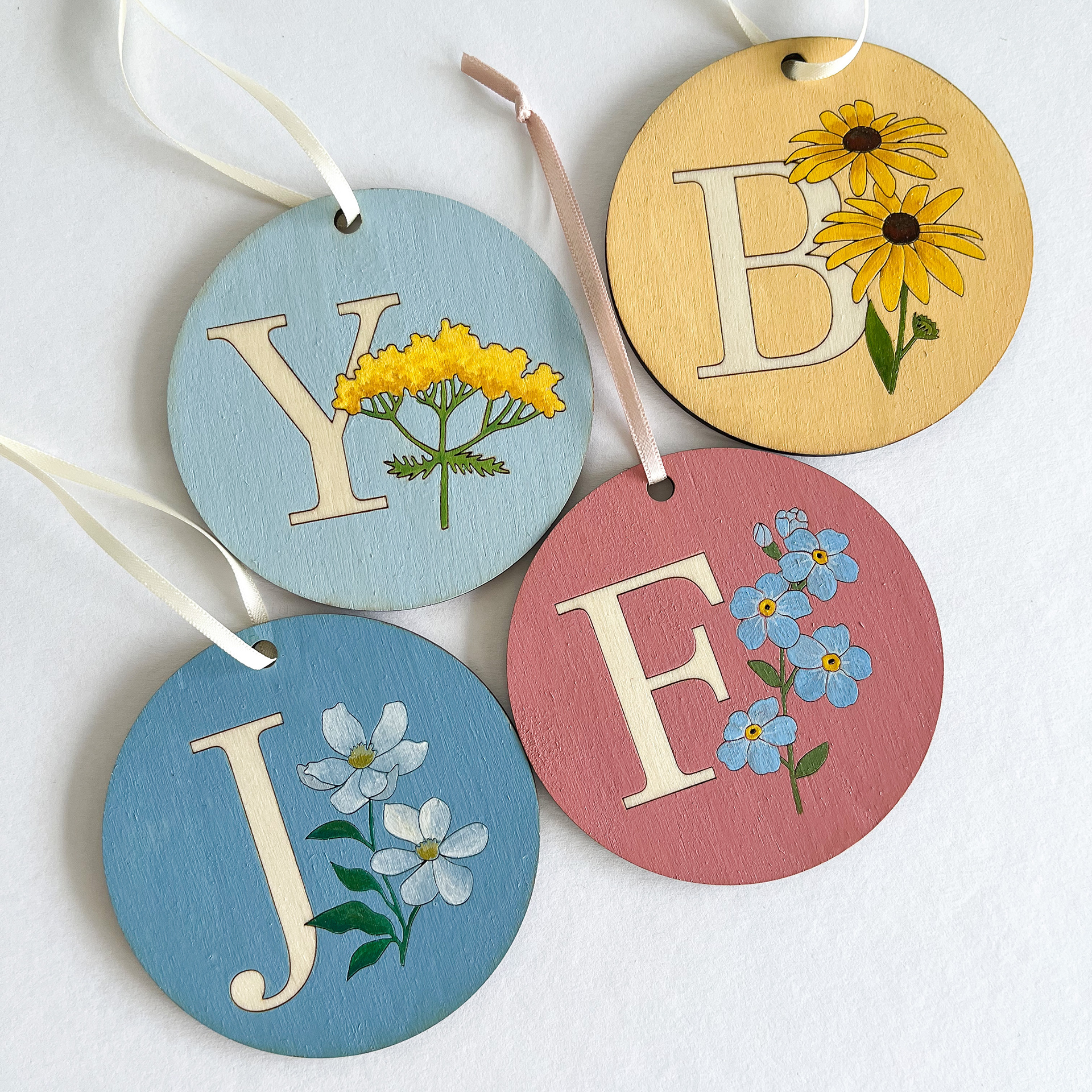 Alphabet flower series. All designed by me, laser cut and hand-painted.