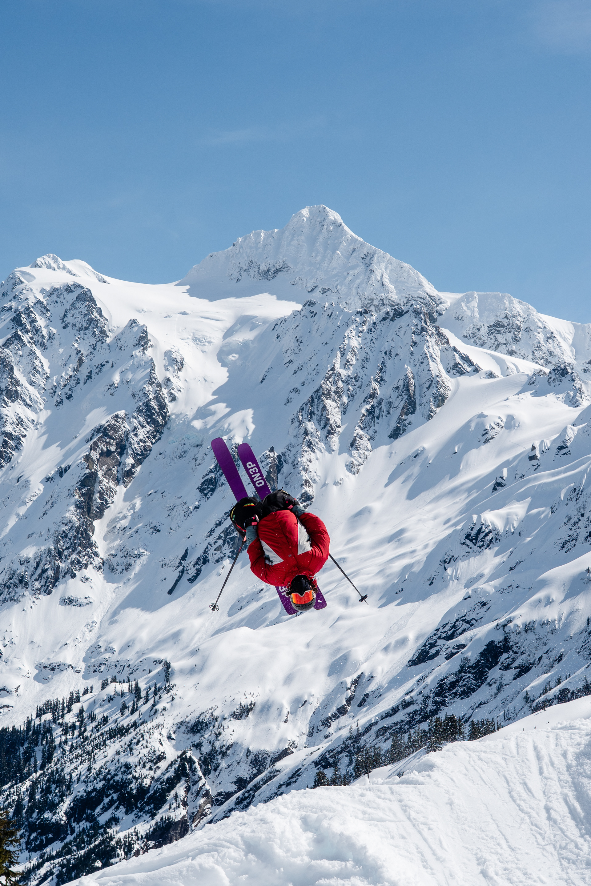 Skier mid-backflip with Mt Shuksan, Mt Baker Ski Area 