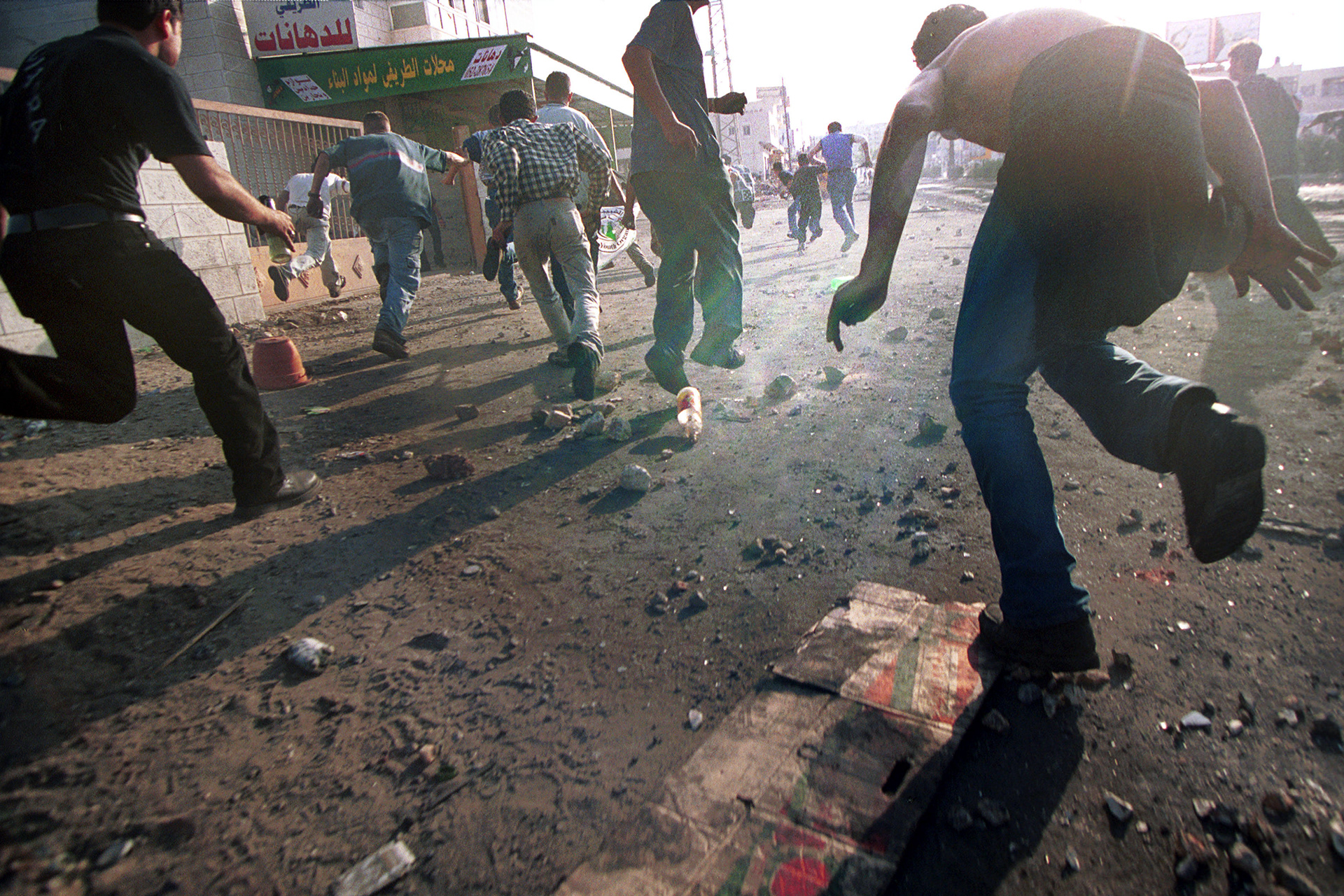 Palestinian protesters run from tear gas and rubber bullets in Ramallah, 2000