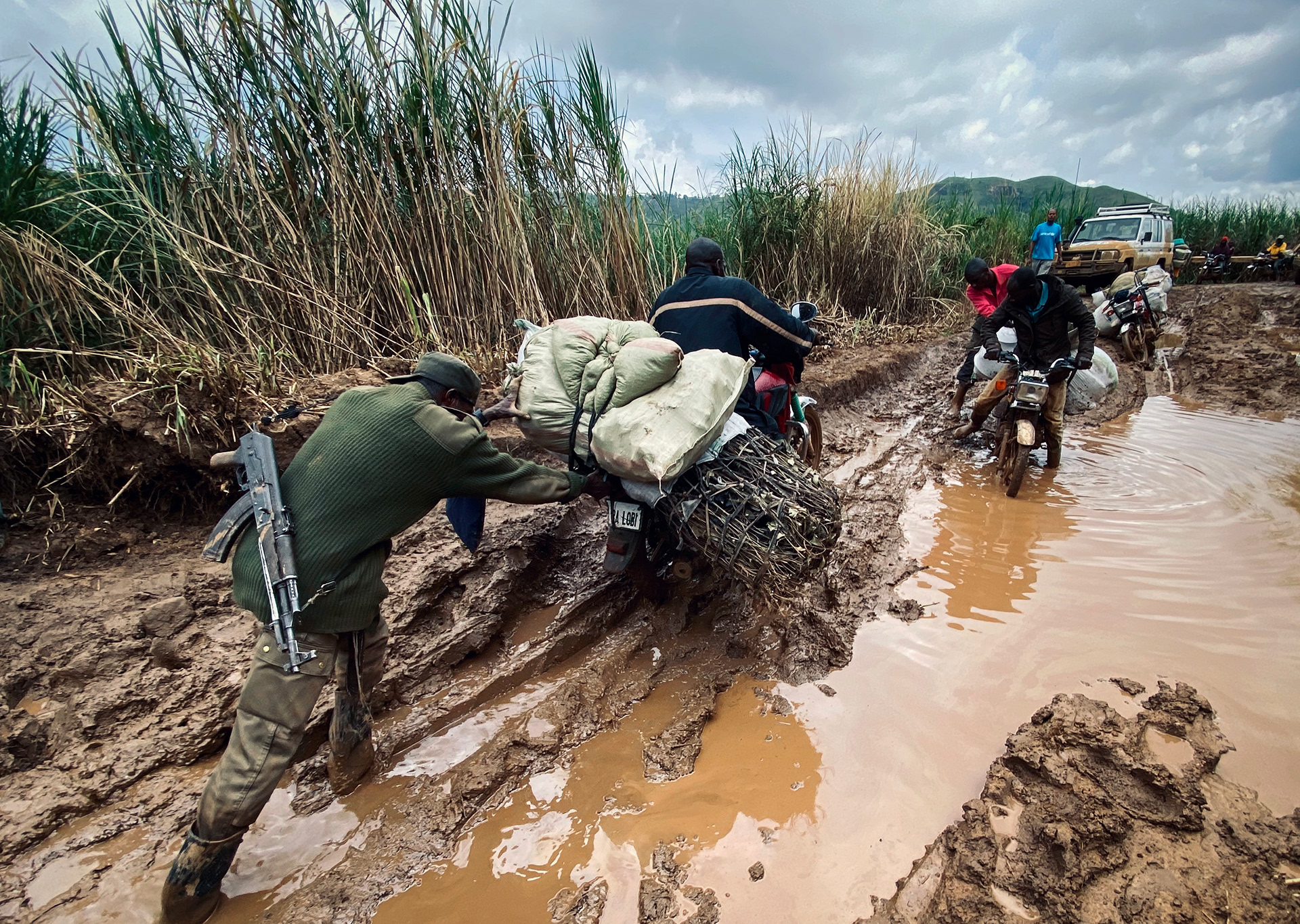 A member of the Congolese army helps a motorcyclist make his way throgh the muddy road between Drodro and Fataki. 