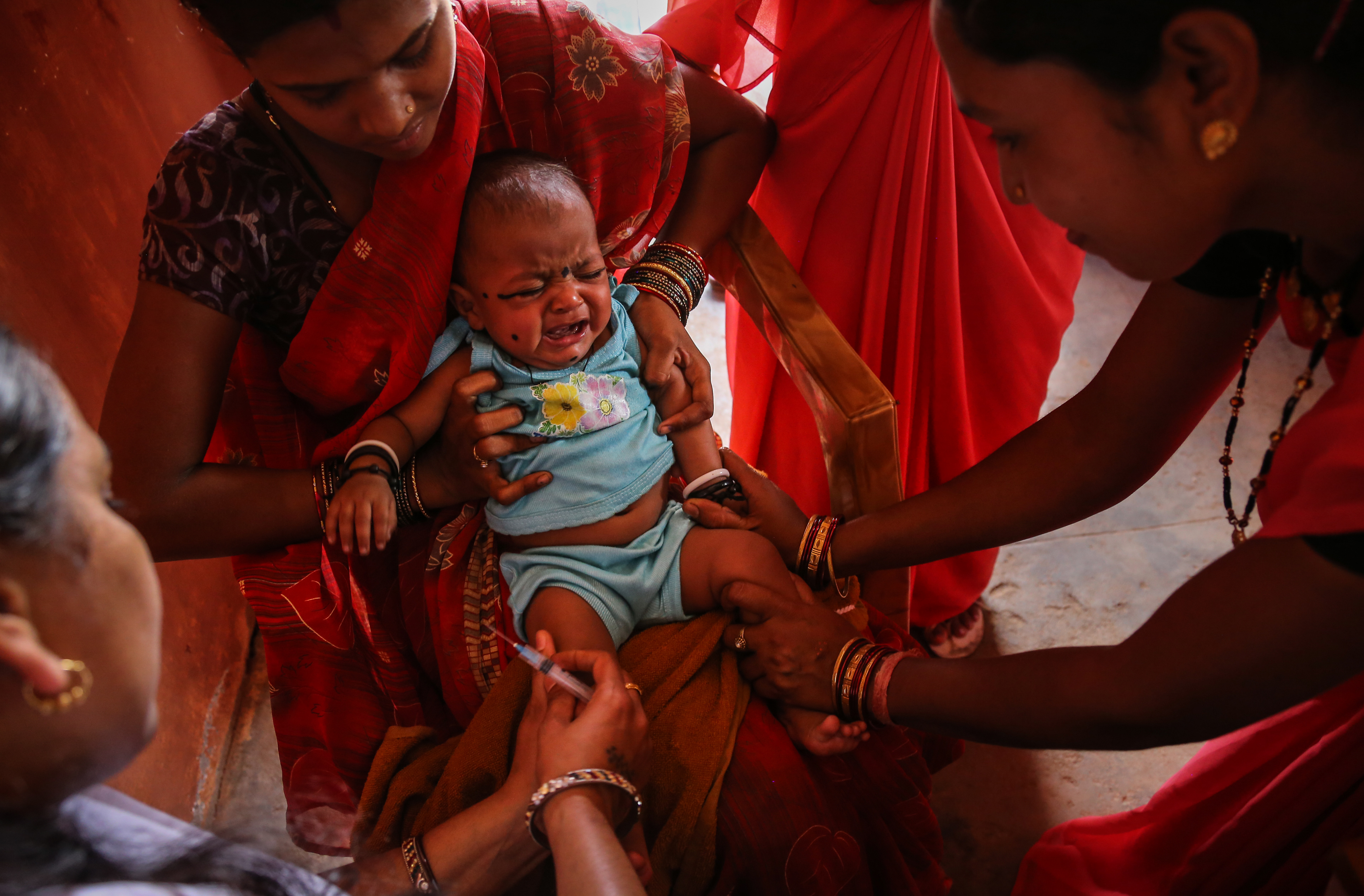 A baby is vaccinated in a village health center, India, 2015 