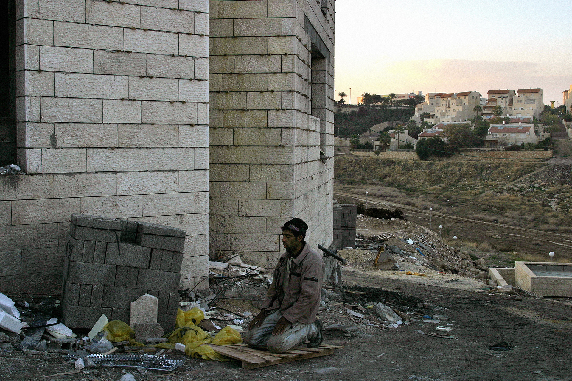 A Palestinian labourer prays on the site of new Israeli settlements in the West Bank. 