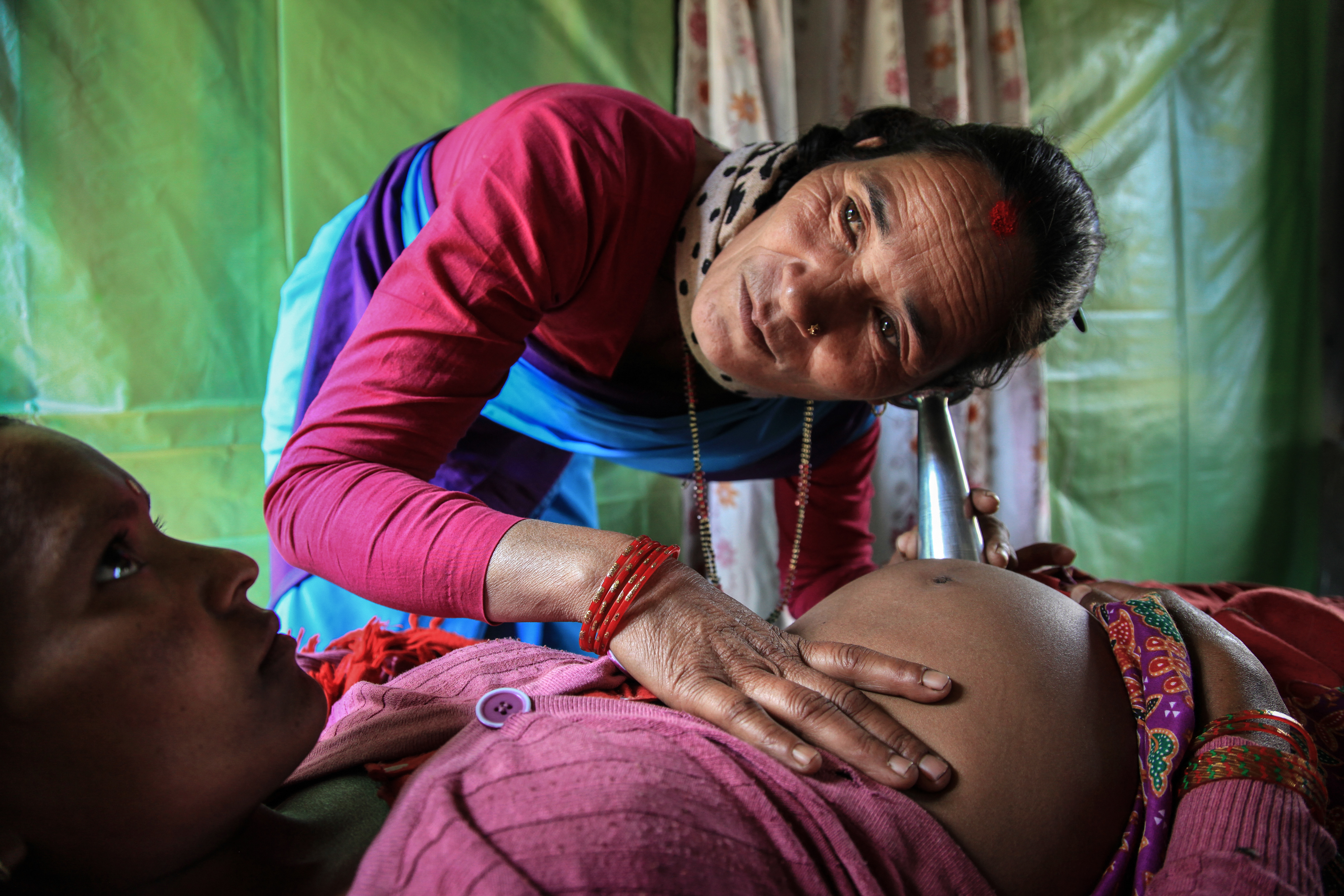 A midwife listens to the baby's heartbeat, Nepal 2015