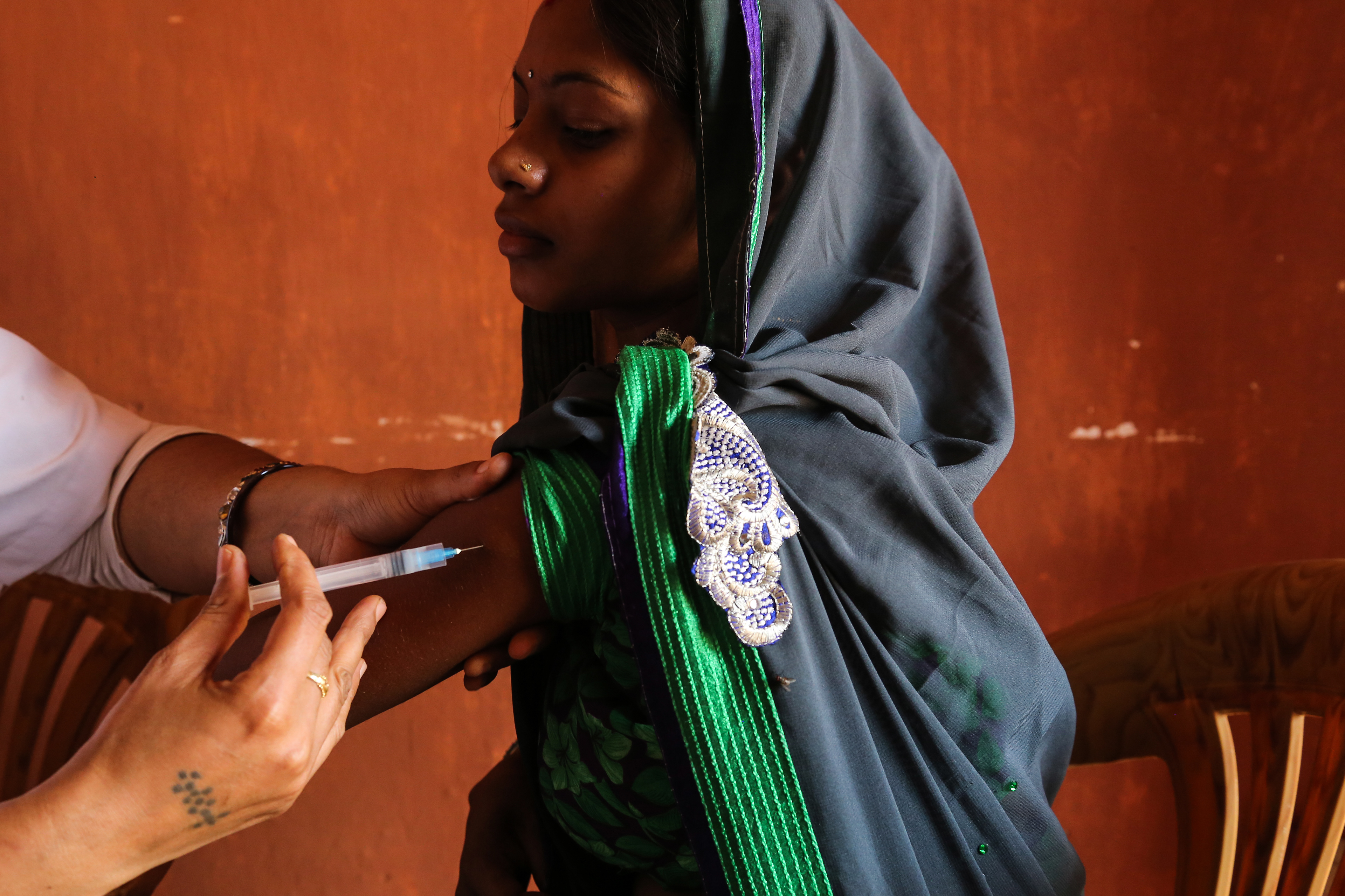 An expectant mother receives a BCG vaccine in a village health center in Raipur,  India, April 2015