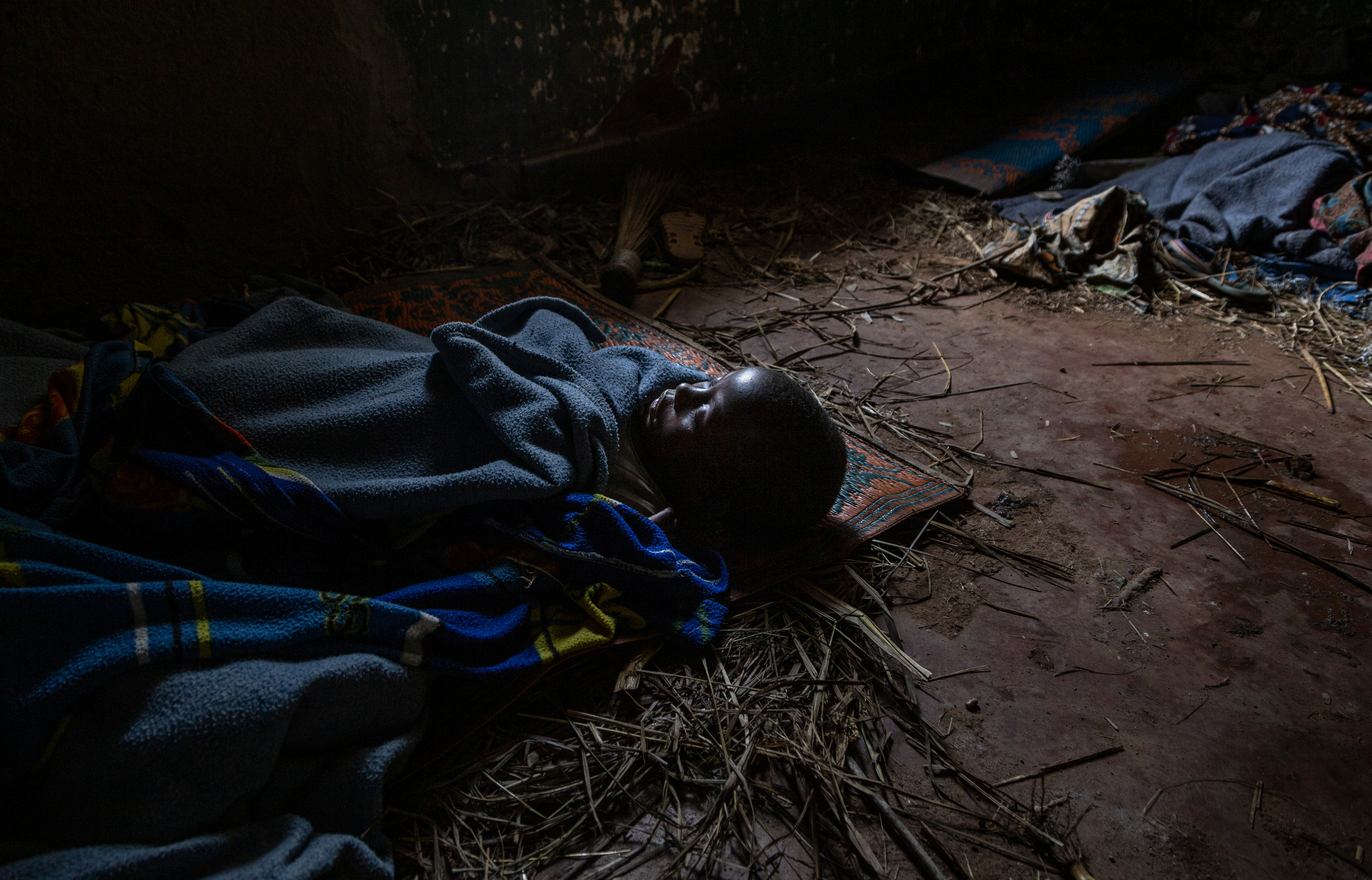 5 year old Elizabeth Nzekuyé sleeps on the floor of an abandoned  colonial era building that forms the center of the IDP camp. in Boga, Ituri Province