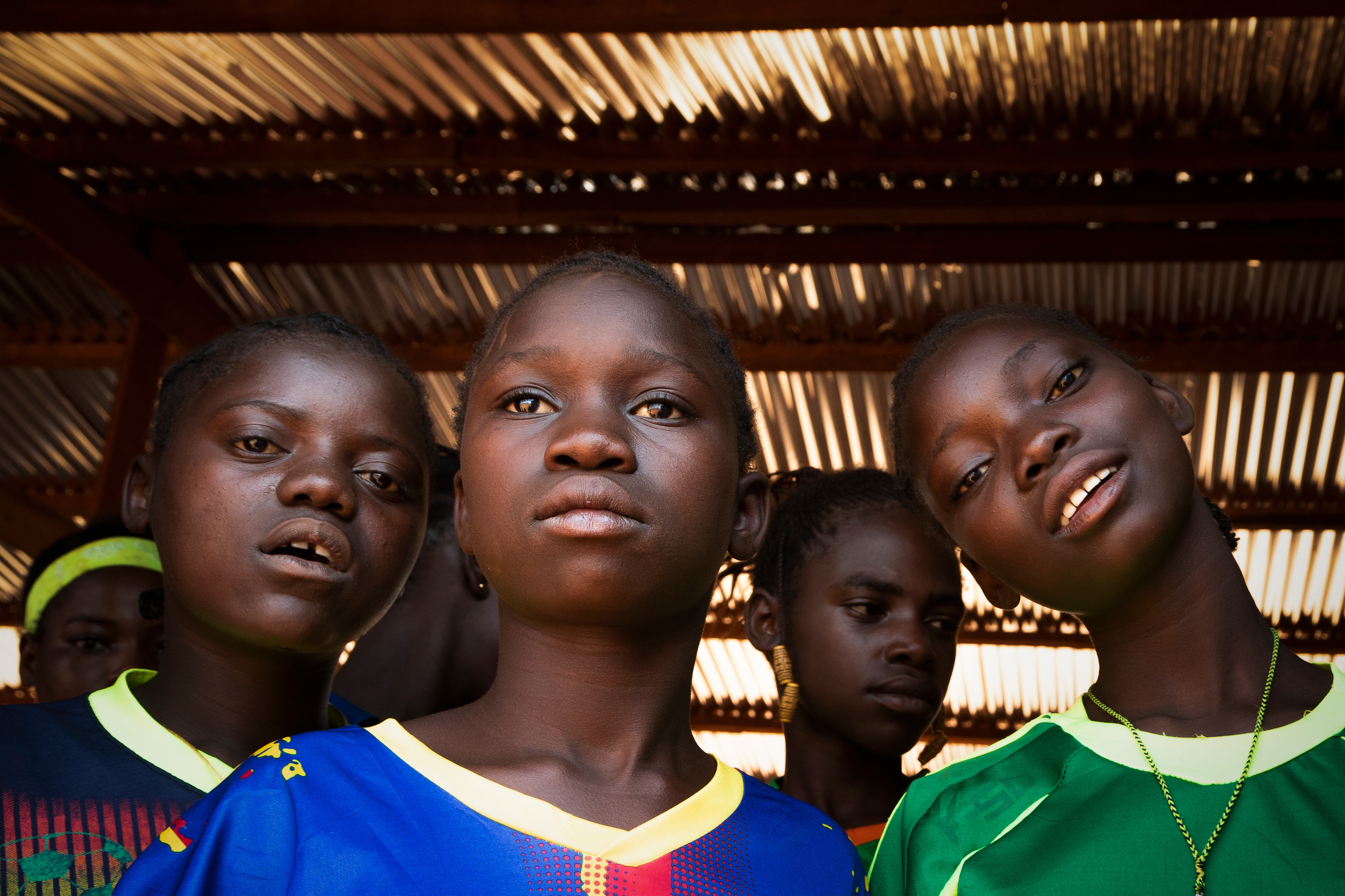 The girls from PK5 camp waiting in the shade for their turn on the football field.