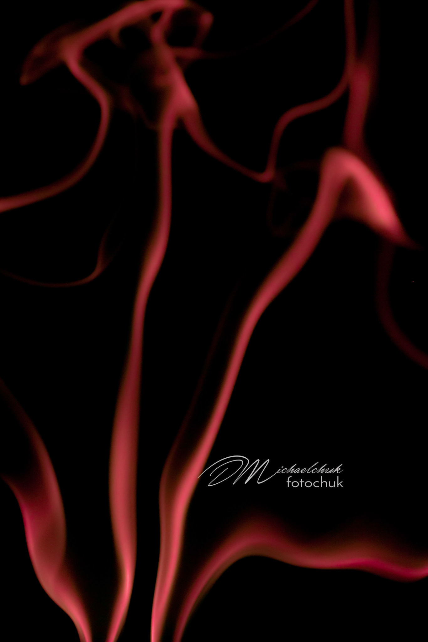Smoke from burning incense showcased in red light.
