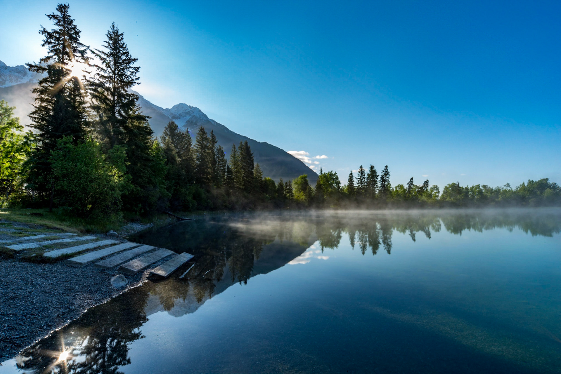 The sun rouse over the mountain and now through the tree on Norbury Lake on a calm srpring morning.