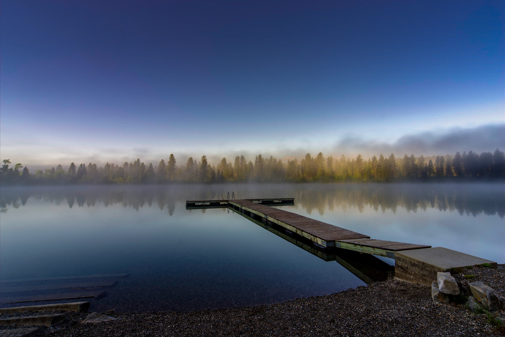 A simulated long exposure image of Norbury Lake as the sun rises from behind the mountains.  Long exposure simulated by blending 26 photos.