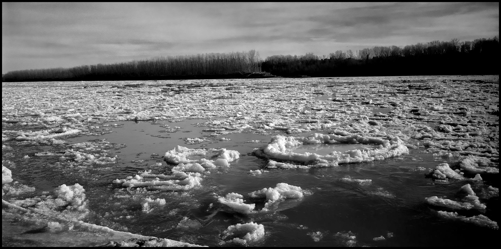 A vintage winter landscape of large chunks of ice flowing downriver at a bend in the Missouri River during the early Spring thaw. Franklin Island near New Franklin, Missouri USA, 1993.