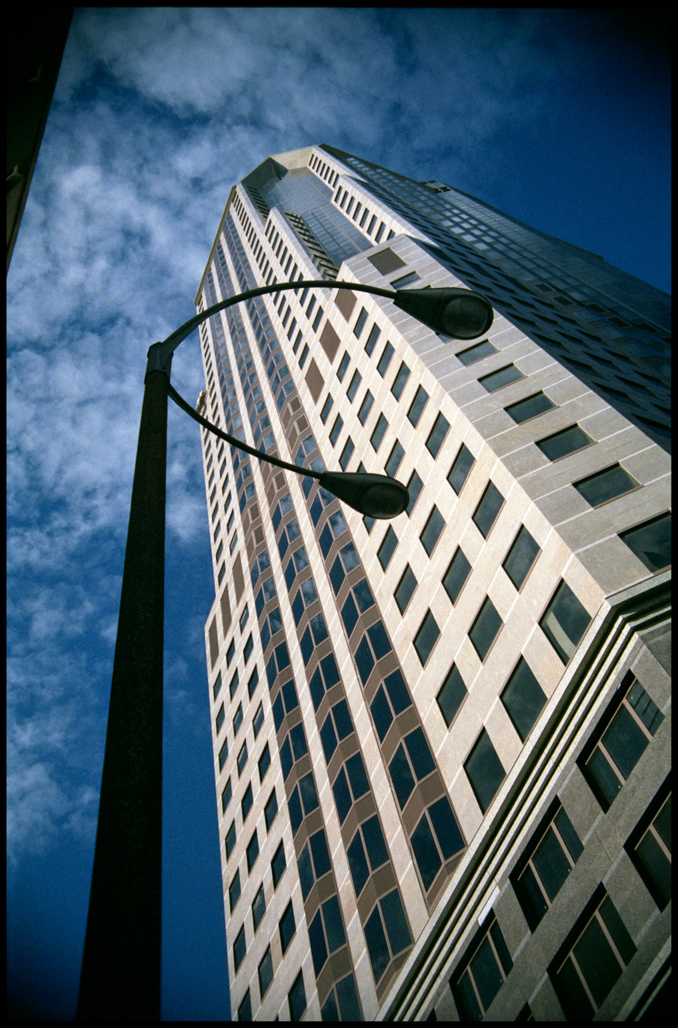 A looming building and streetlight face off in downtown St. Louis, Missouri. Part of a series shot one warm afternoon in November, 1988 called An Afternoon in St. Louis (a subset of my Industrial Geometry series).