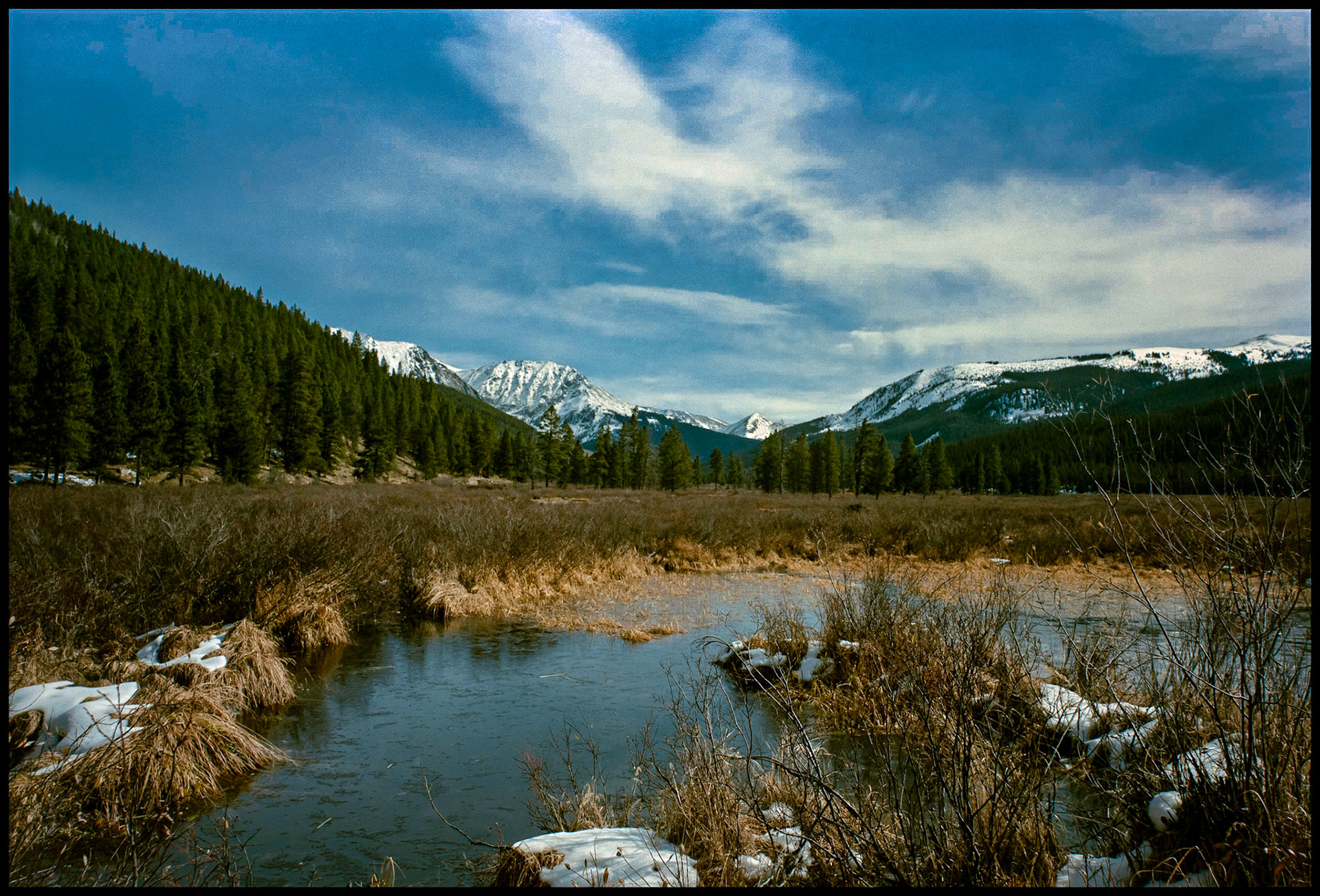 A view of the snowcapped Collegiate Peaks area in the Sawatch mountain range from the shore of one of the Texas Lakes in Taylor Park near Tincup, Colorado USA